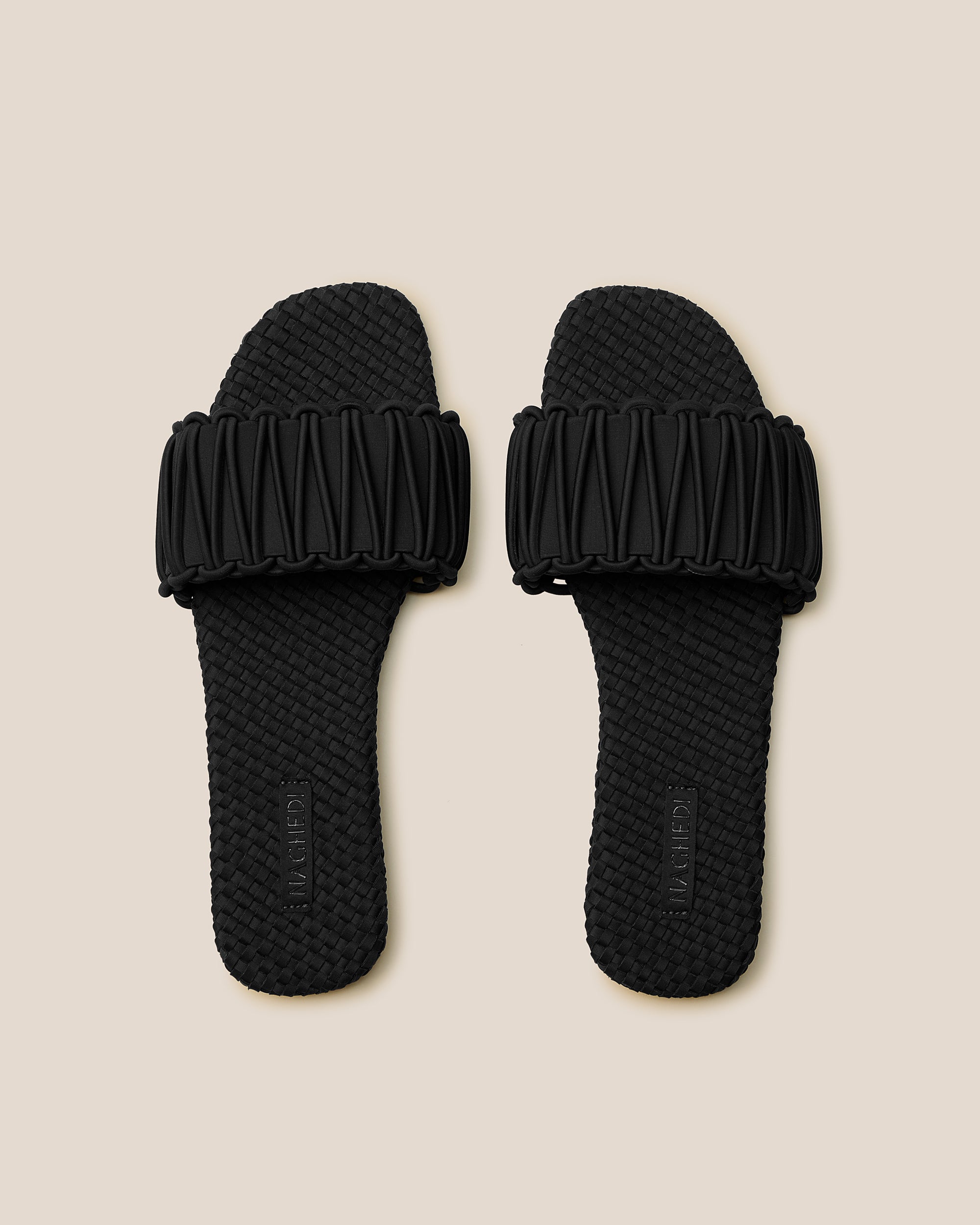 Top view of pair of The Athens Slide in Onyx showing the handwoven neoprene insole.