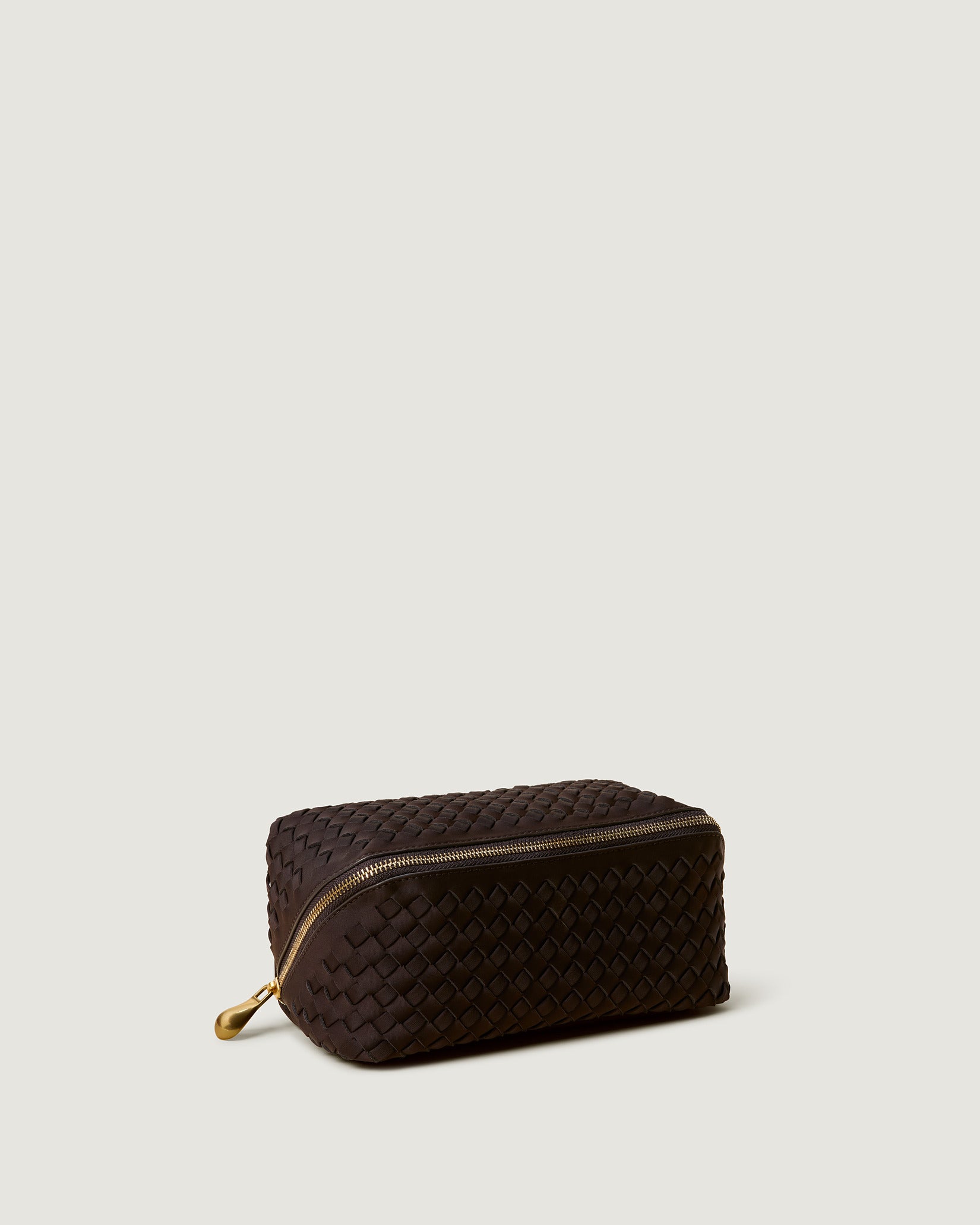 Caravan Cosmetic Case in Chocolate shown from a side angle, highlighting its handwoven neoprene construction and wrap-around zip closure.