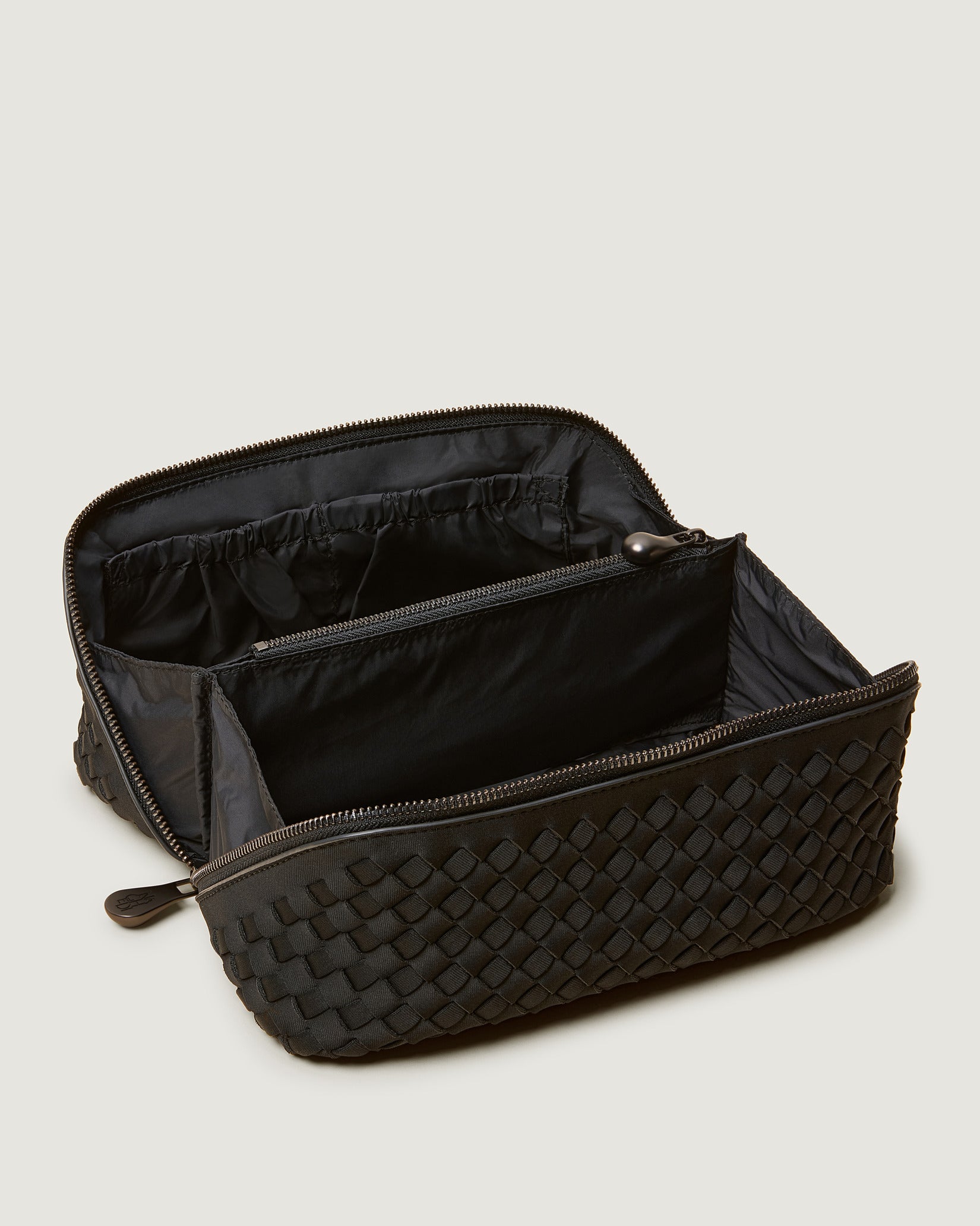 Interior close-up of Caravan Cosmetic Case in Onyx showing its wrap-around zip closure, and wipe-clean nylon interior.