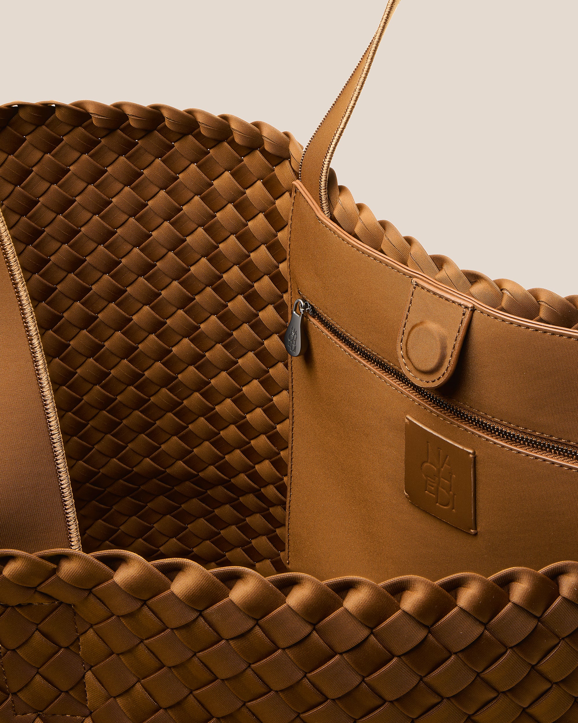 Interior close-up of Como Tote in Teak showing its open top with magnetic snap closure, interior zip pocket, and unlined interior.