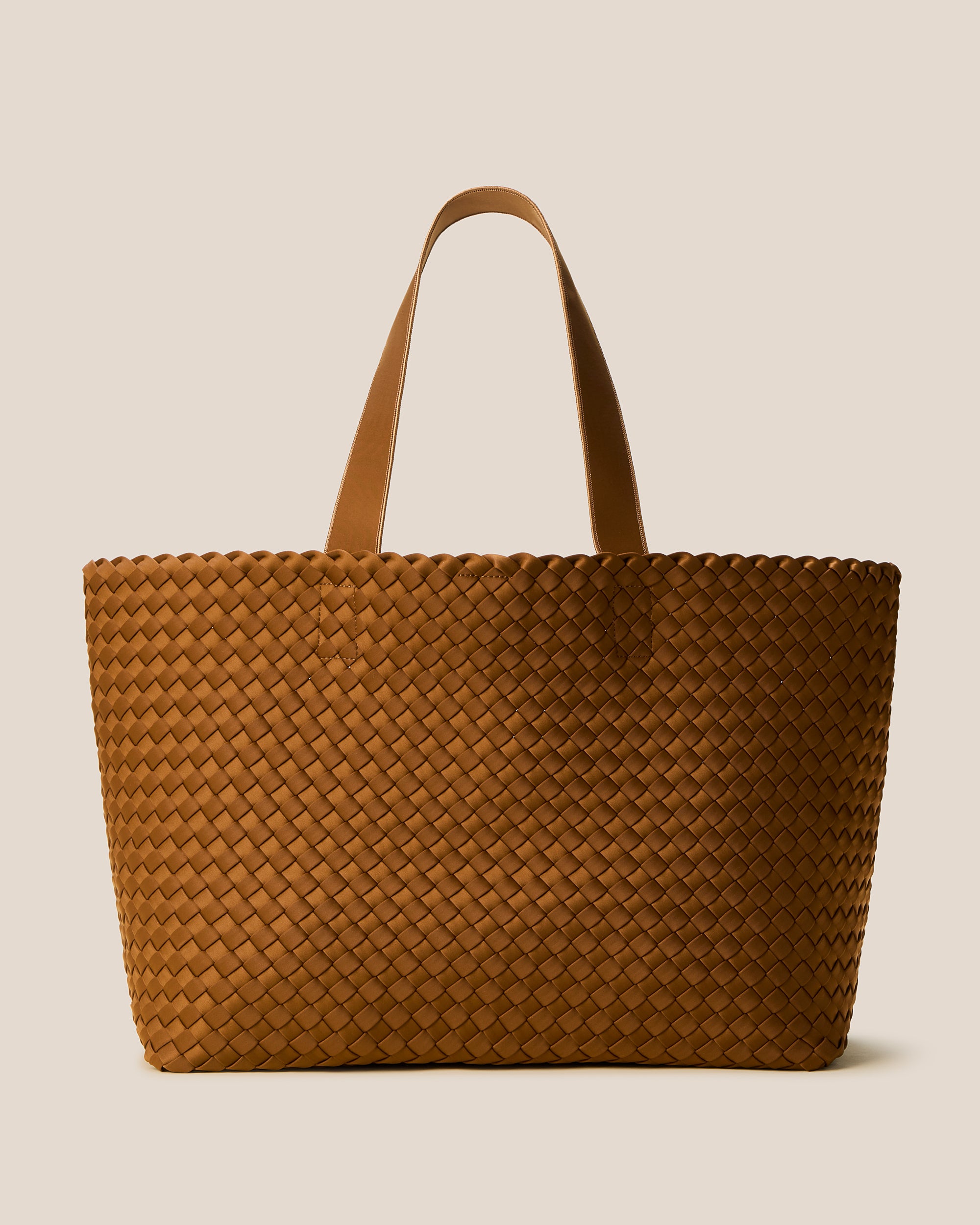 Como Tote in Teak, a saddle brown tone, in handwoven neoprene, featuring an open top with magnetic snap closure, and neoprene shoulder straps.