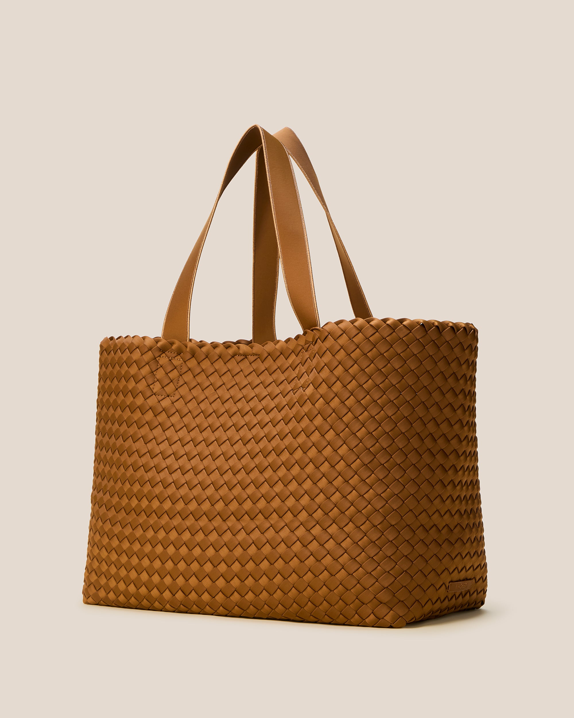Como Tote in Teak shown from a side angle, highlighting its handwoven neoprene construction and open top with magnetic snap closure.