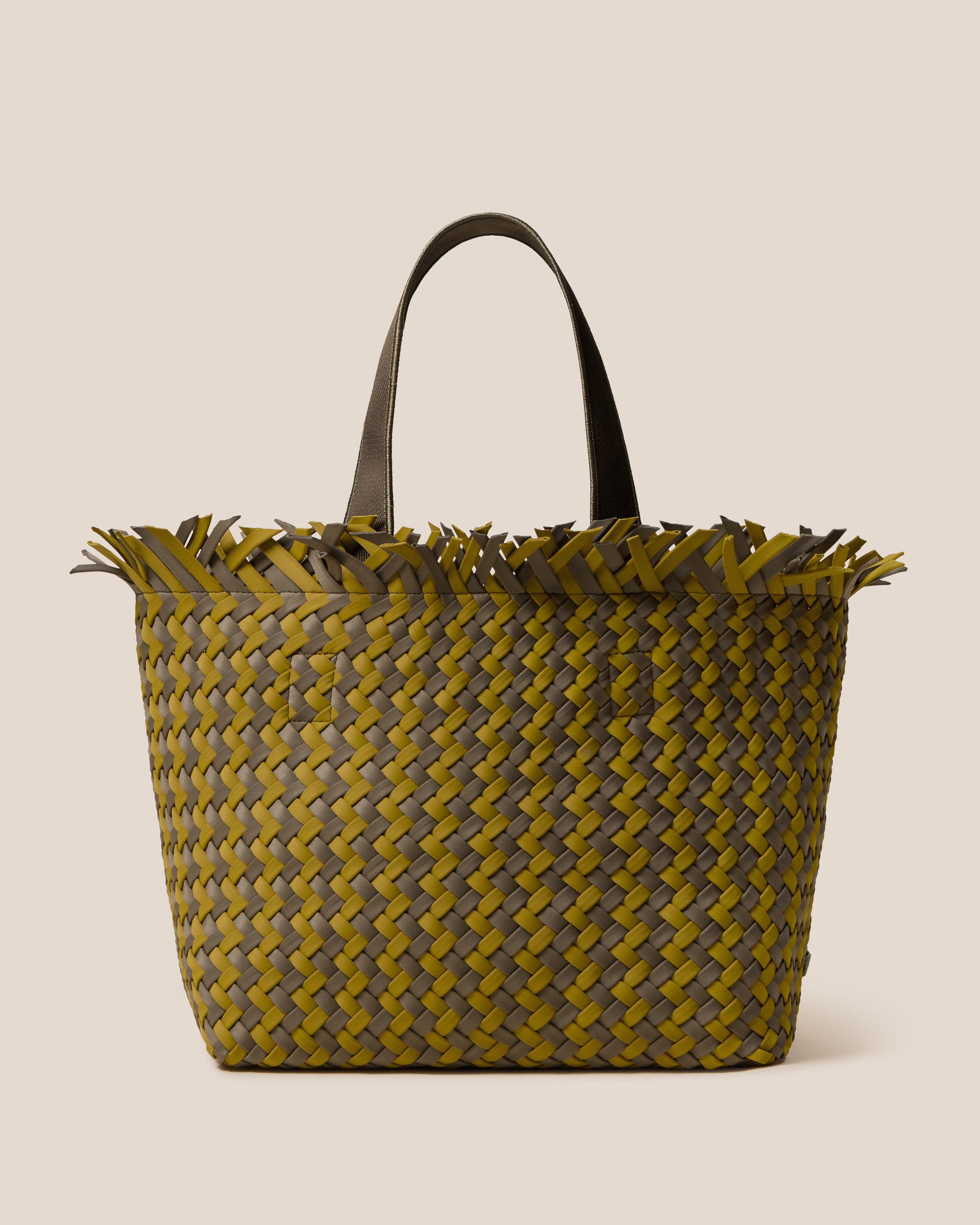 Havana  in Palma, a yellow-green and muted earh brown tone, in handwoven neoprene, featuring an open top with magnetic snap closure, and sleek nylon webbing handles fit over the shoulder.