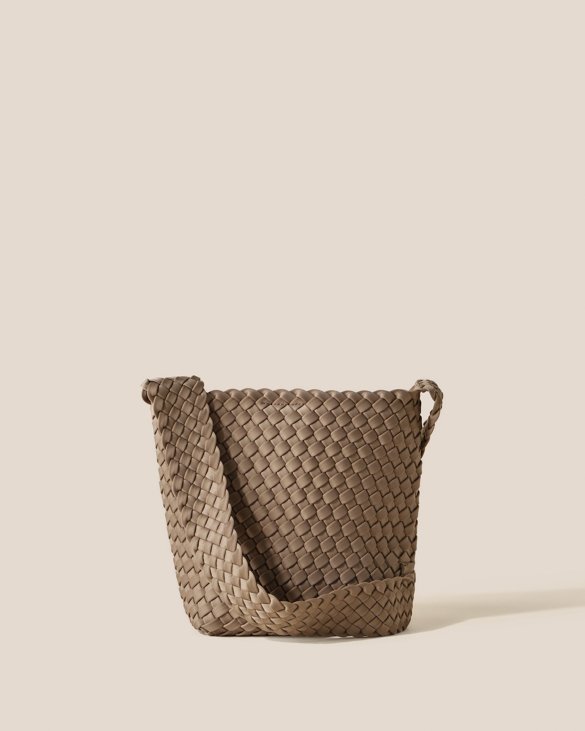Laguna Crossbody in Cashmere, a taupe tone, in handwoven neoprene, featuring an open top with magnetic snap closure, and handwoven crossbody strap lays comfortably flat.