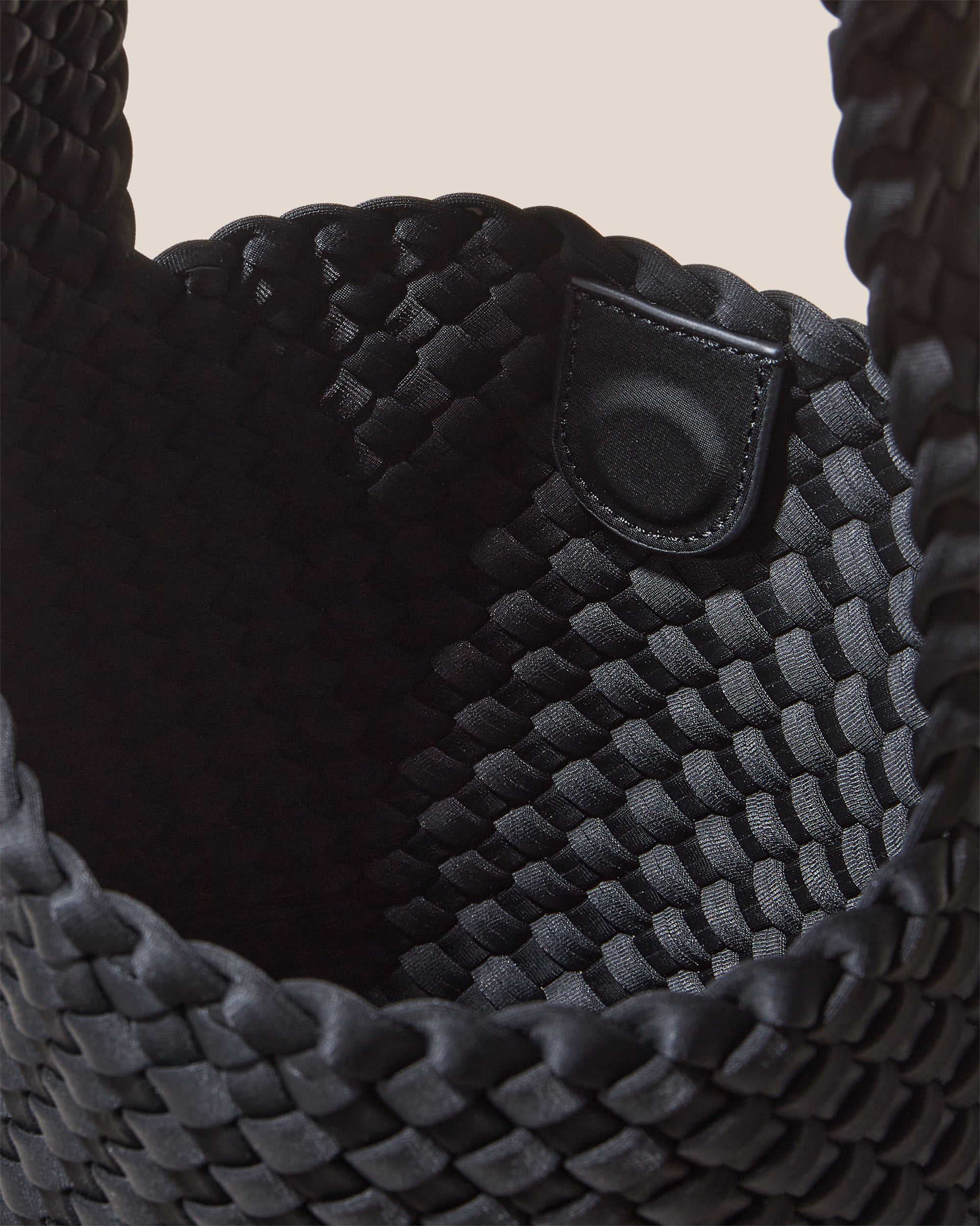 Interior close-up of Laguna Crossbody in Onyx showing its open top with magnetic snap closure, and unlined interior.