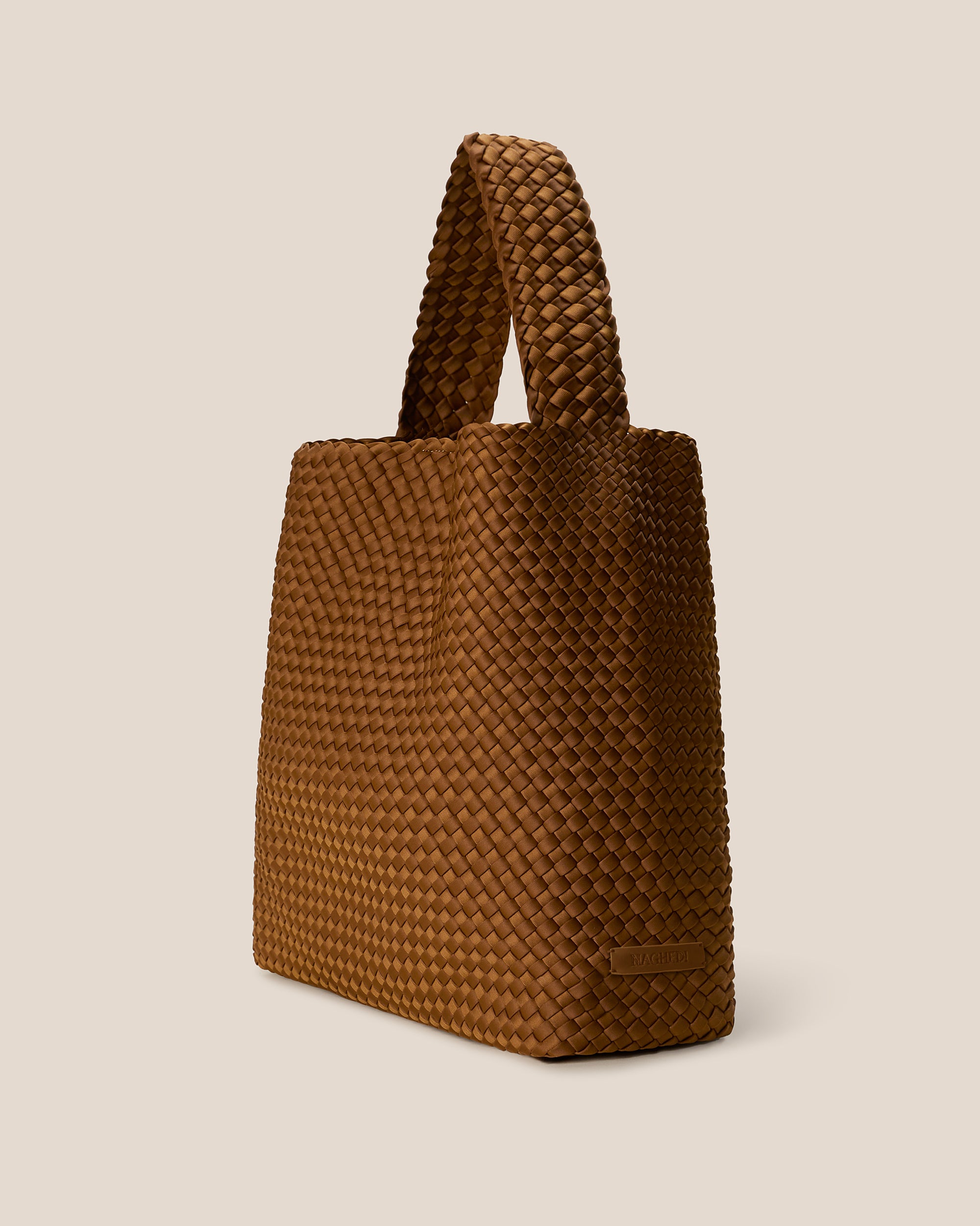 Nomad Hobo in Teak shown from a side angle, highlighting its handwoven neoprene construction and open top with magnetic snap closure.