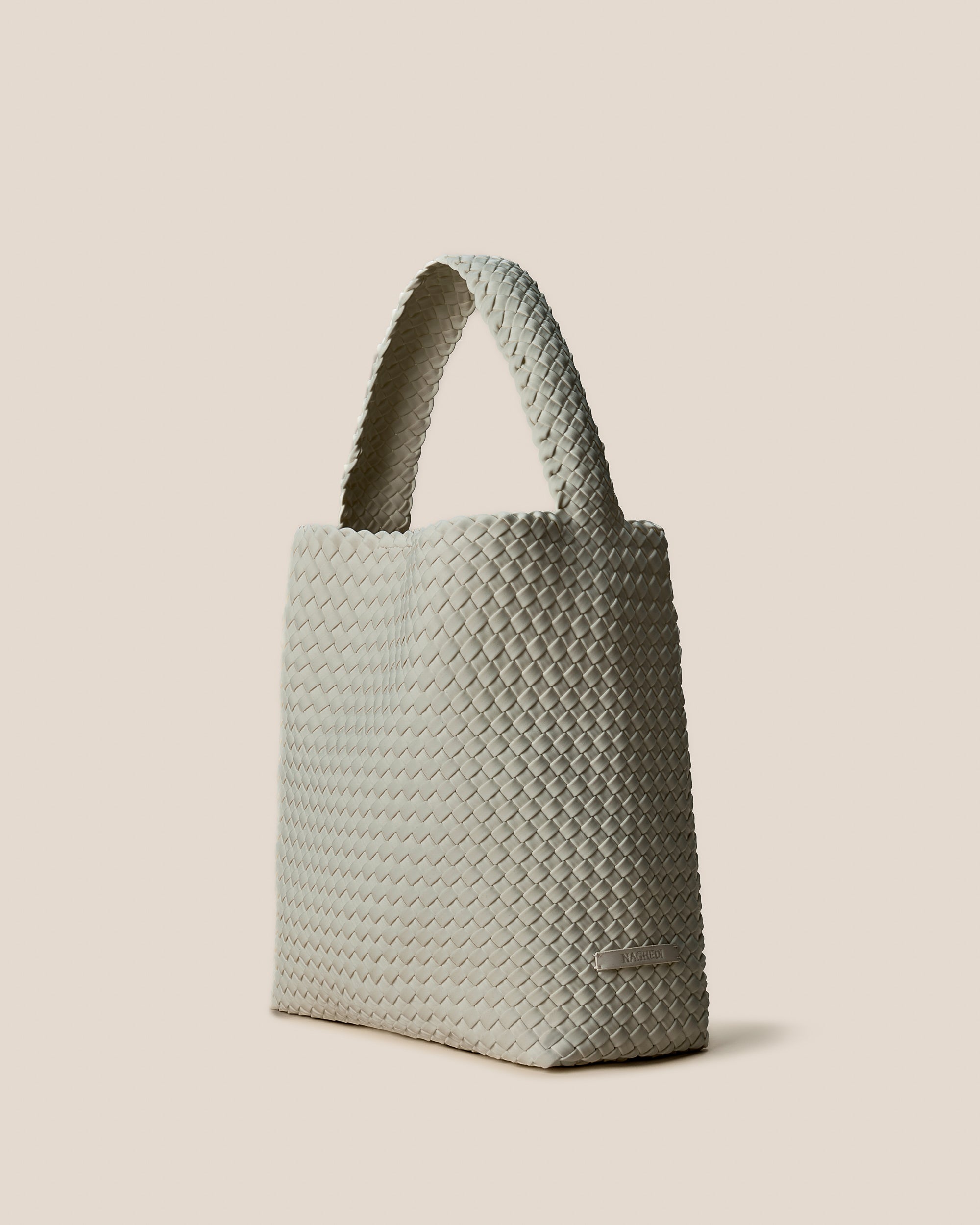 Nomad Hobo in Celadon shown from a side angle, highlighting its handwoven neoprene construction and open top with magnetic snap closure.