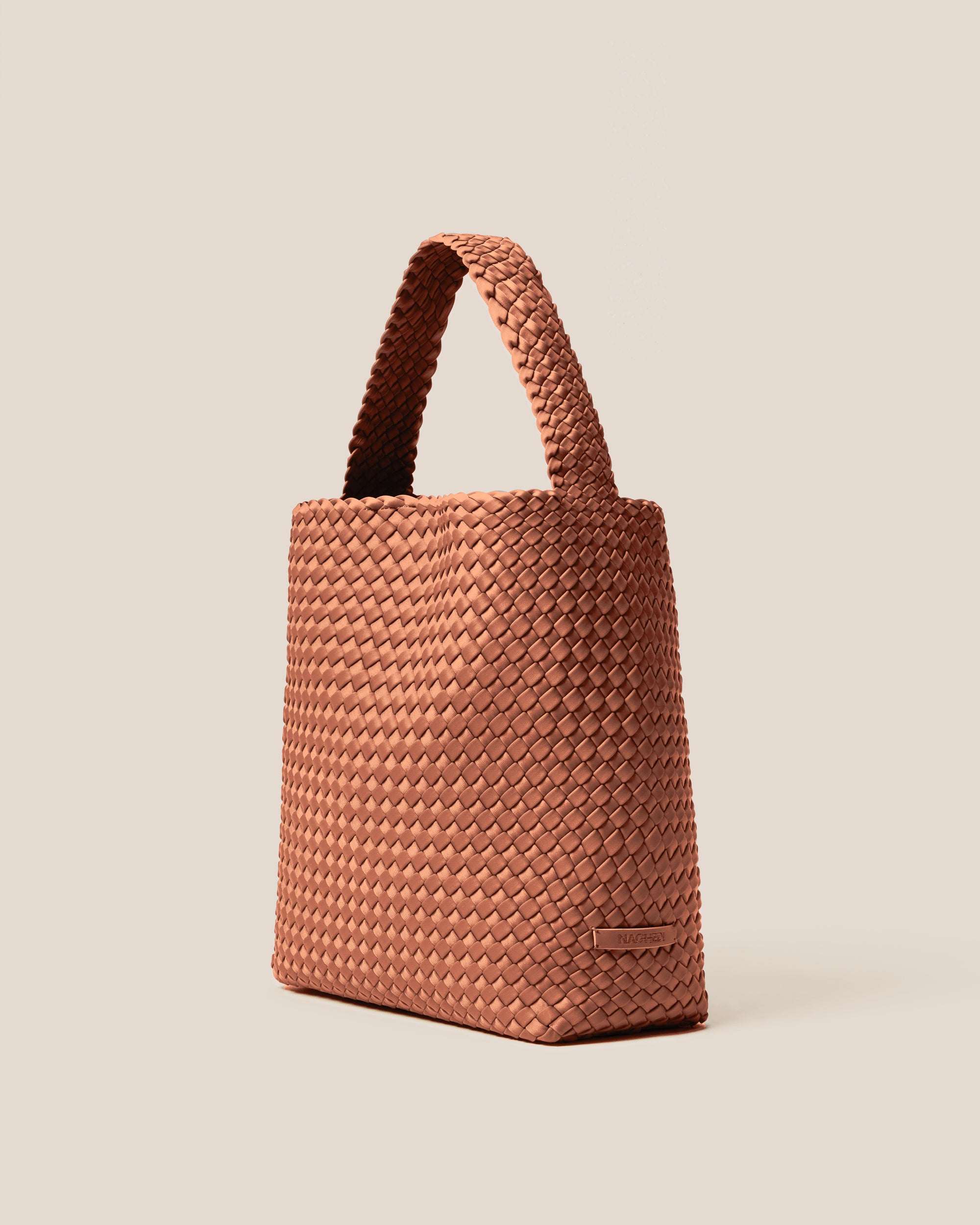 Nomad Hobo in Cocoa shown from a side angle, highlighting its handwoven neoprene construction and open top with magnetic snap closure.