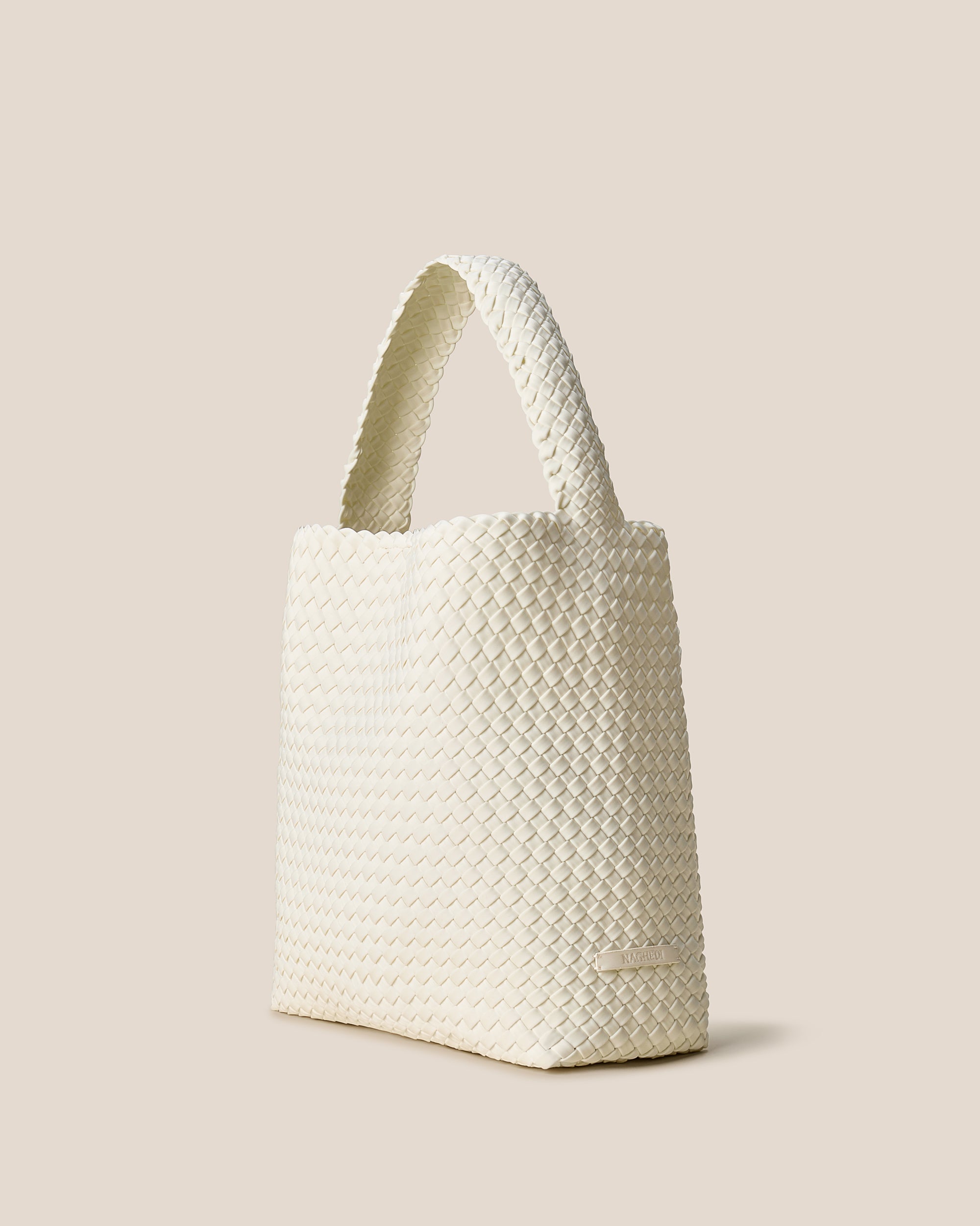 Nomad Hobo in Jasmine shown from a side angle, highlighting its handwoven neoprene construction and open top with magnetic snap closure.
