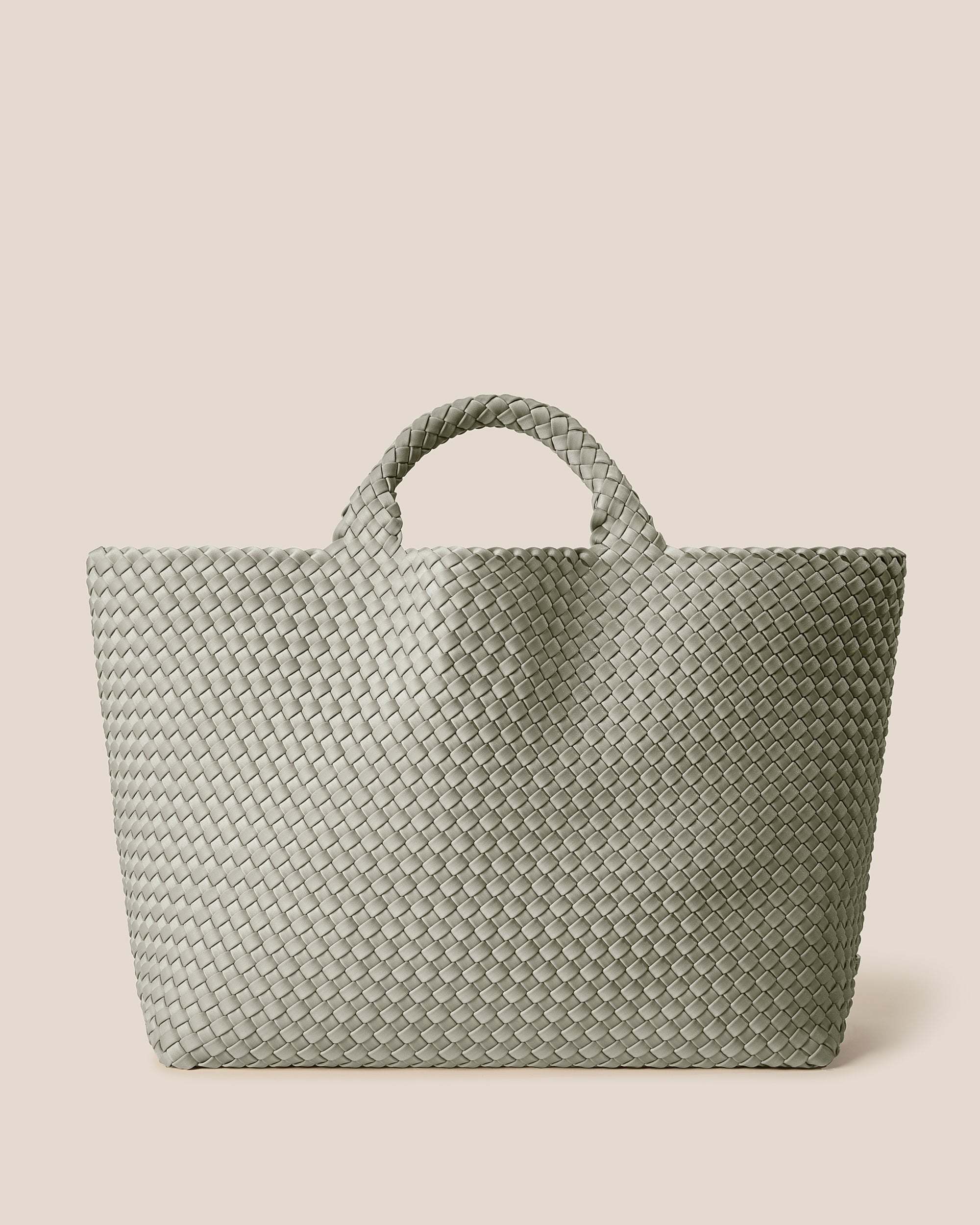 St. Barths Tote in Celadon, a light jade green tone, in handwoven neoprene, featuring an open top, and woven top handles.
