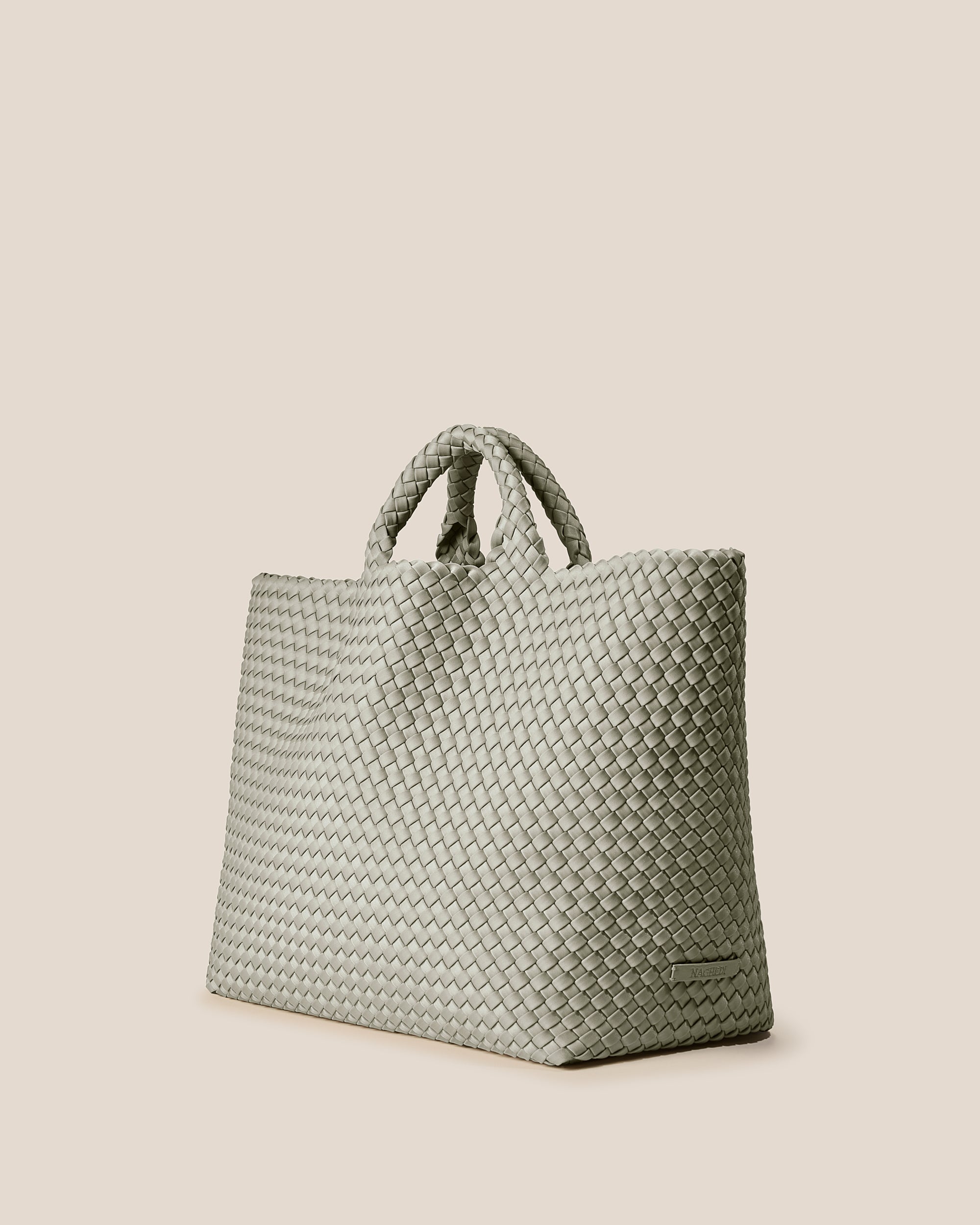 St. Barths Tote in Celadon shown from a side angle, highlighting its handwoven neoprene construction and open top.