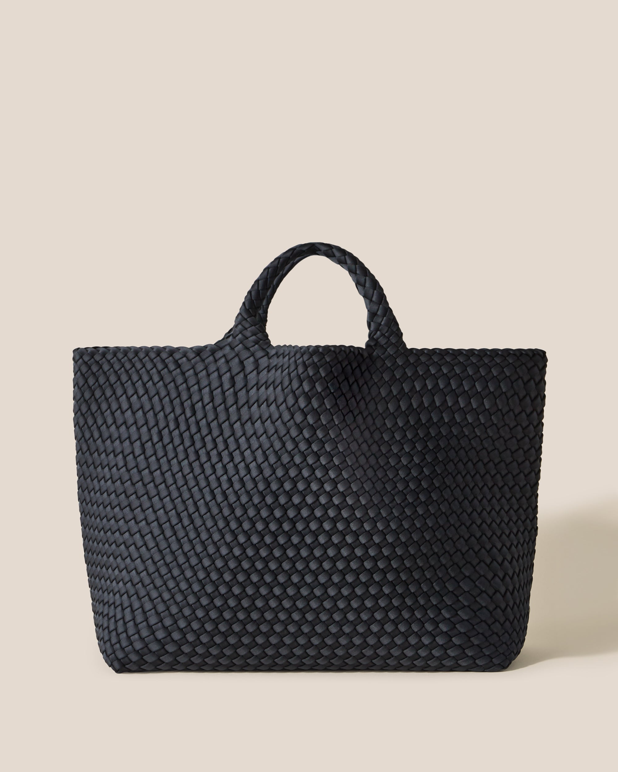 St. Barths Tote in Onyx, a true black tone, in handwoven neoprene, featuring an open top, and woven top handles.