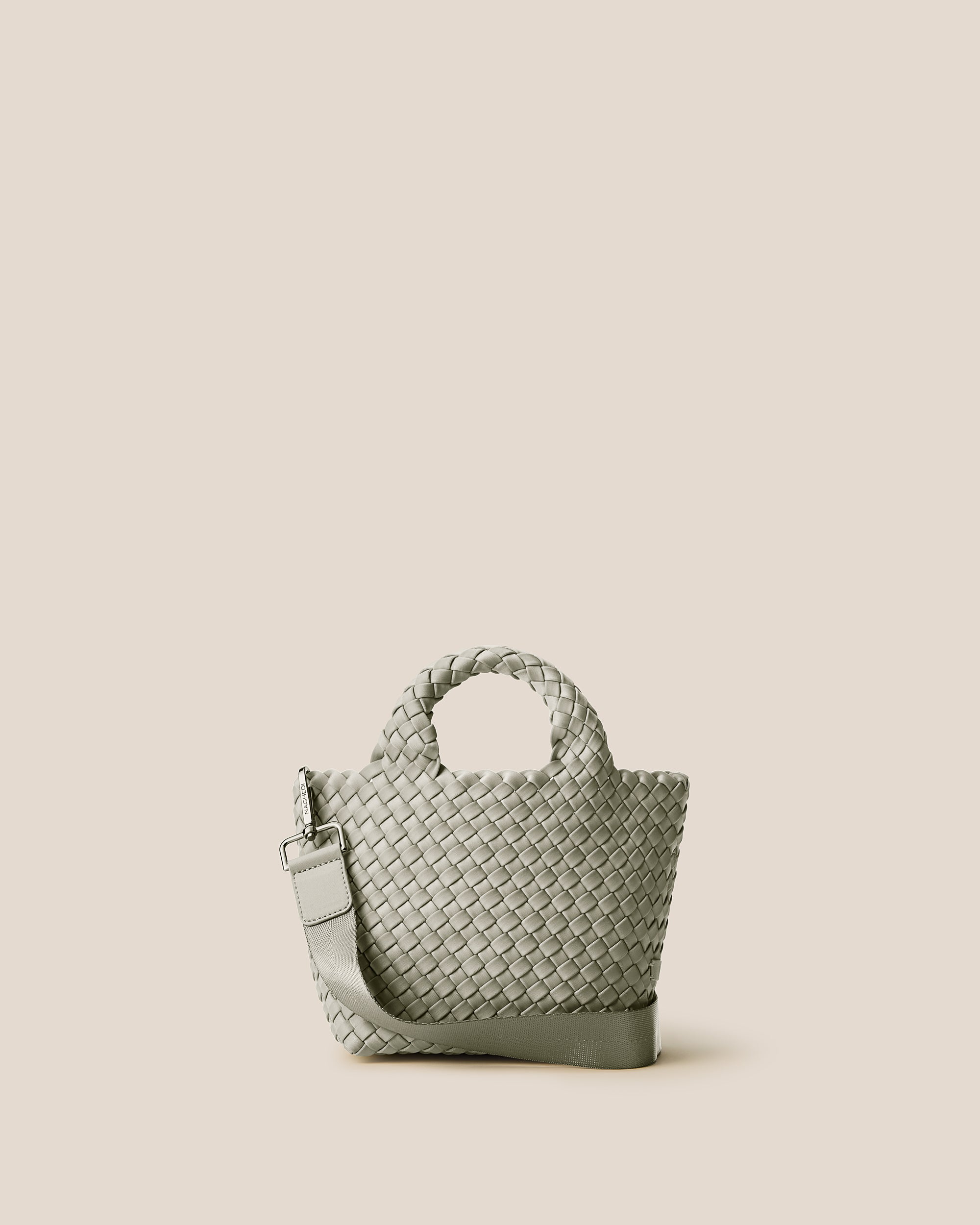 St. Barths Tote in Celadon, a light jade green tone, in handwoven neoprene, featuring an open top, woven top handles, and detachable, adjustable nylon crossbody strap.
