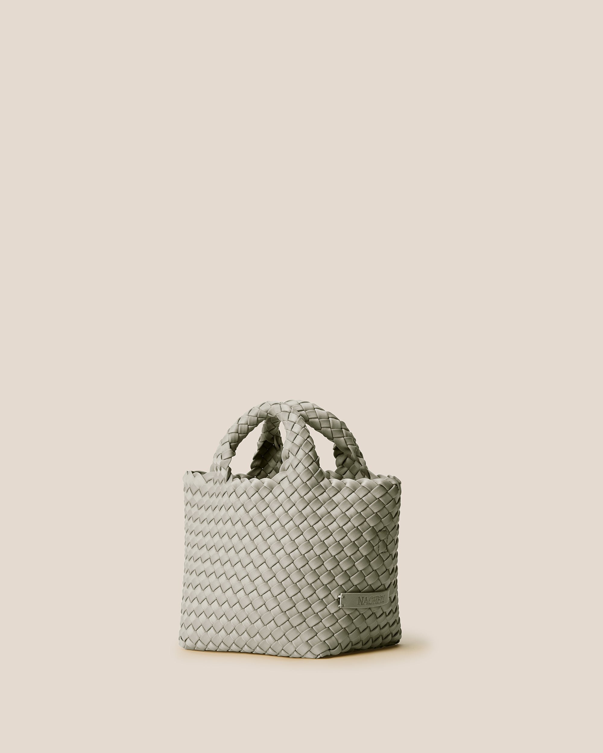 St. Barths Tote in Celadon shown from a side angle, highlighting its handwoven neoprene construction and open top.