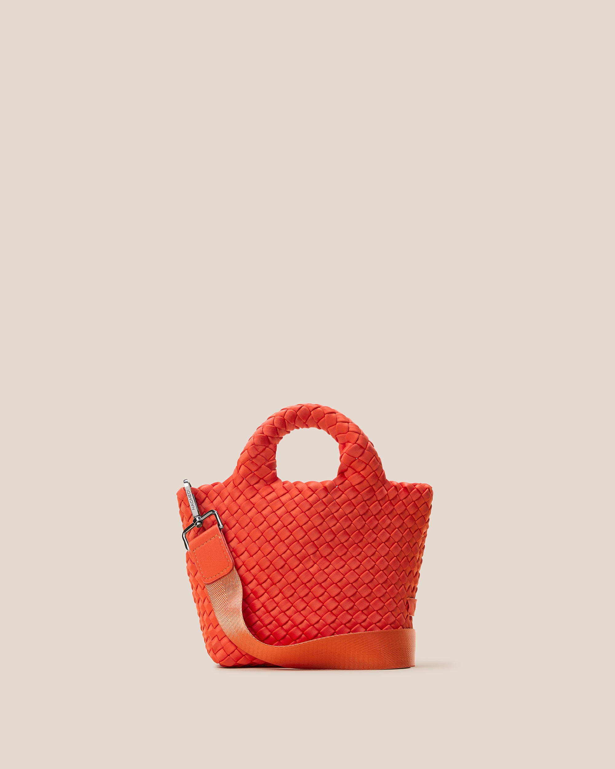 St. Barths Tote in Ipanema, a vibrant orange tone, in handwoven neoprene, featuring an open top, woven top handles, and detachable, adjustable nylon crossbody strap.