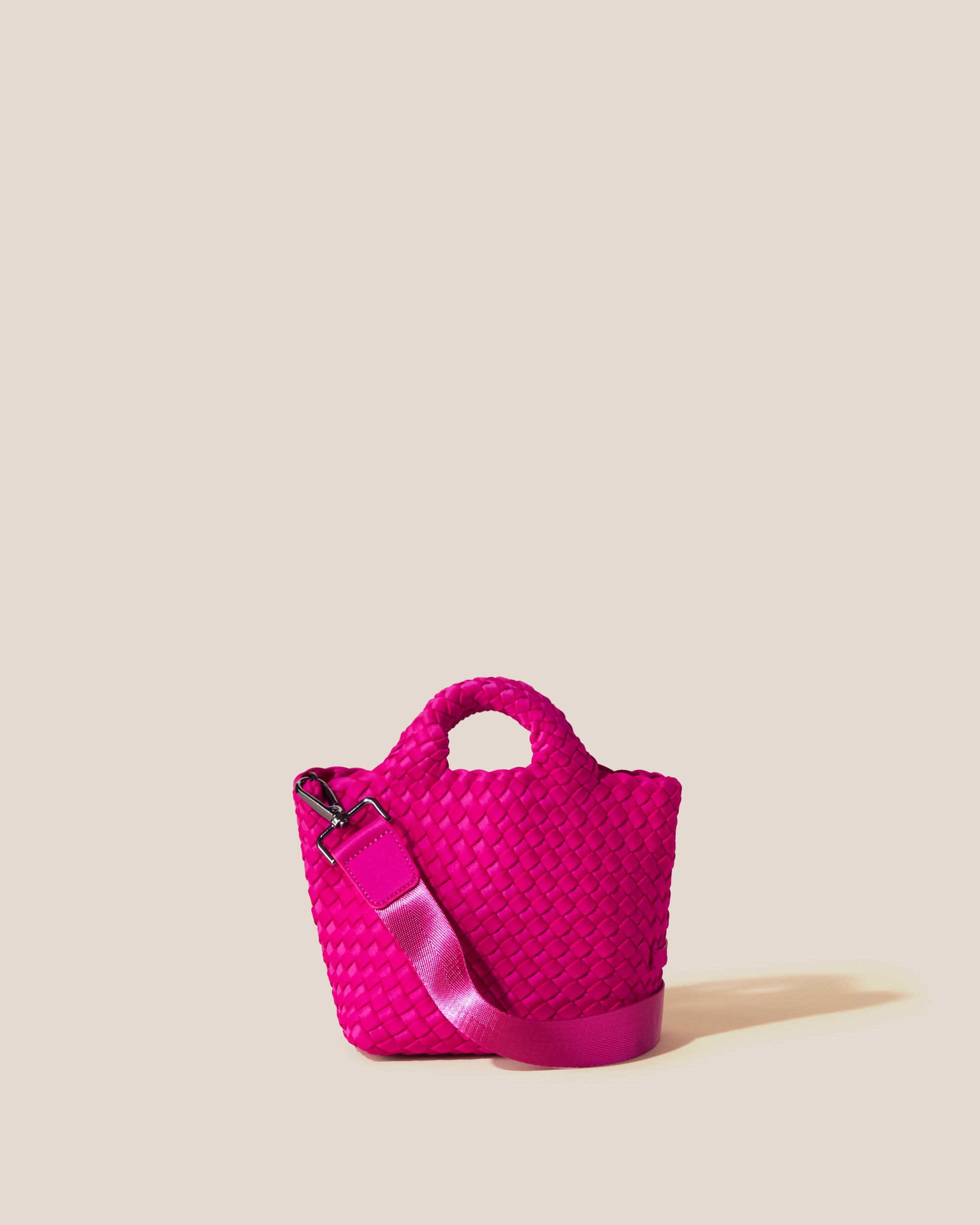 St. Barths Tote in Miami Pink, a vibrant pink tone, in handwoven neoprene, featuring an open top, woven top handles, and detachable, adjustable nylon crossbody strap.
