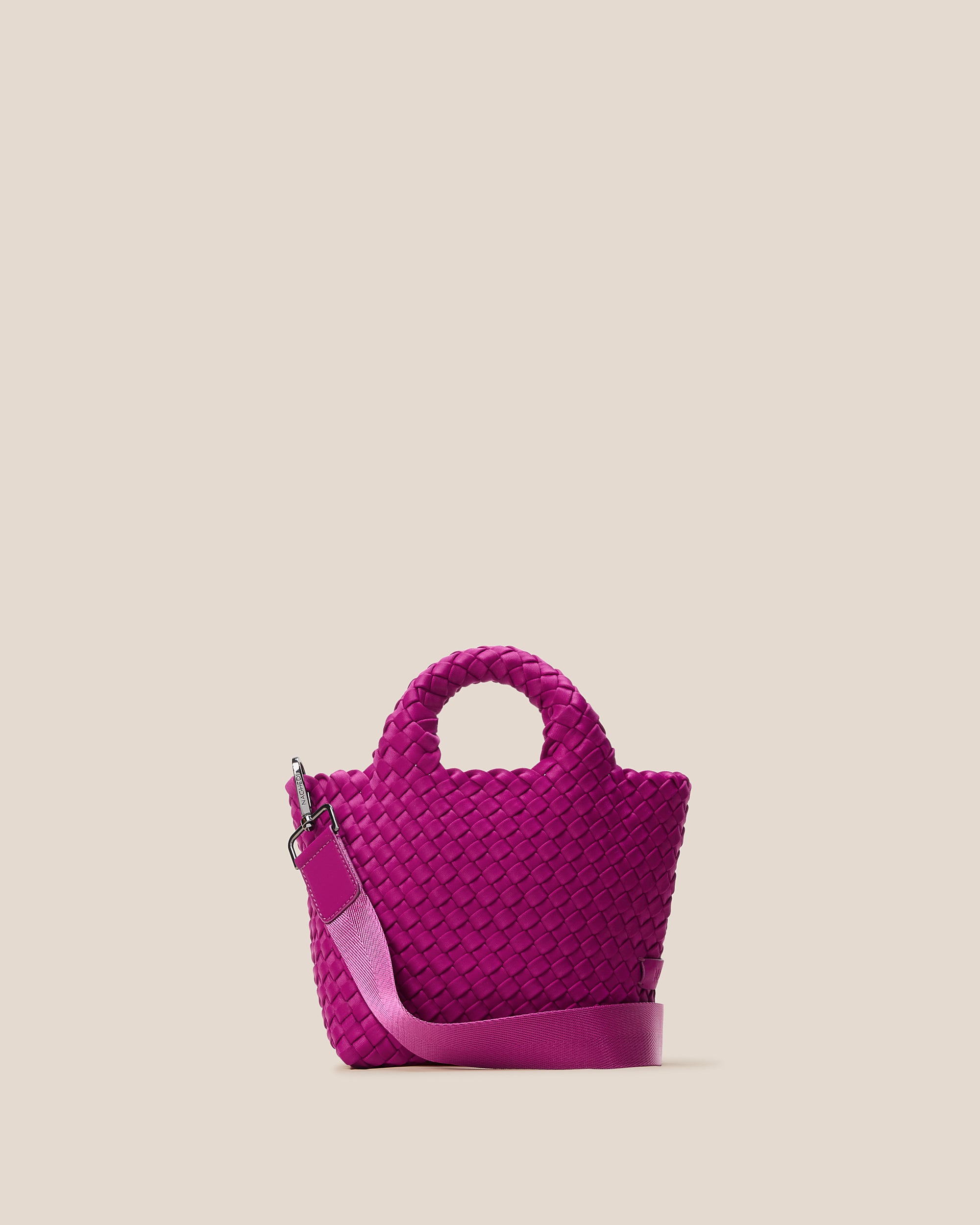 St. Barths Tote in Rio, a fuchsia tone, in handwoven neoprene, featuring an open top, woven top handles, and detachable, adjustable nylon crossbody strap.