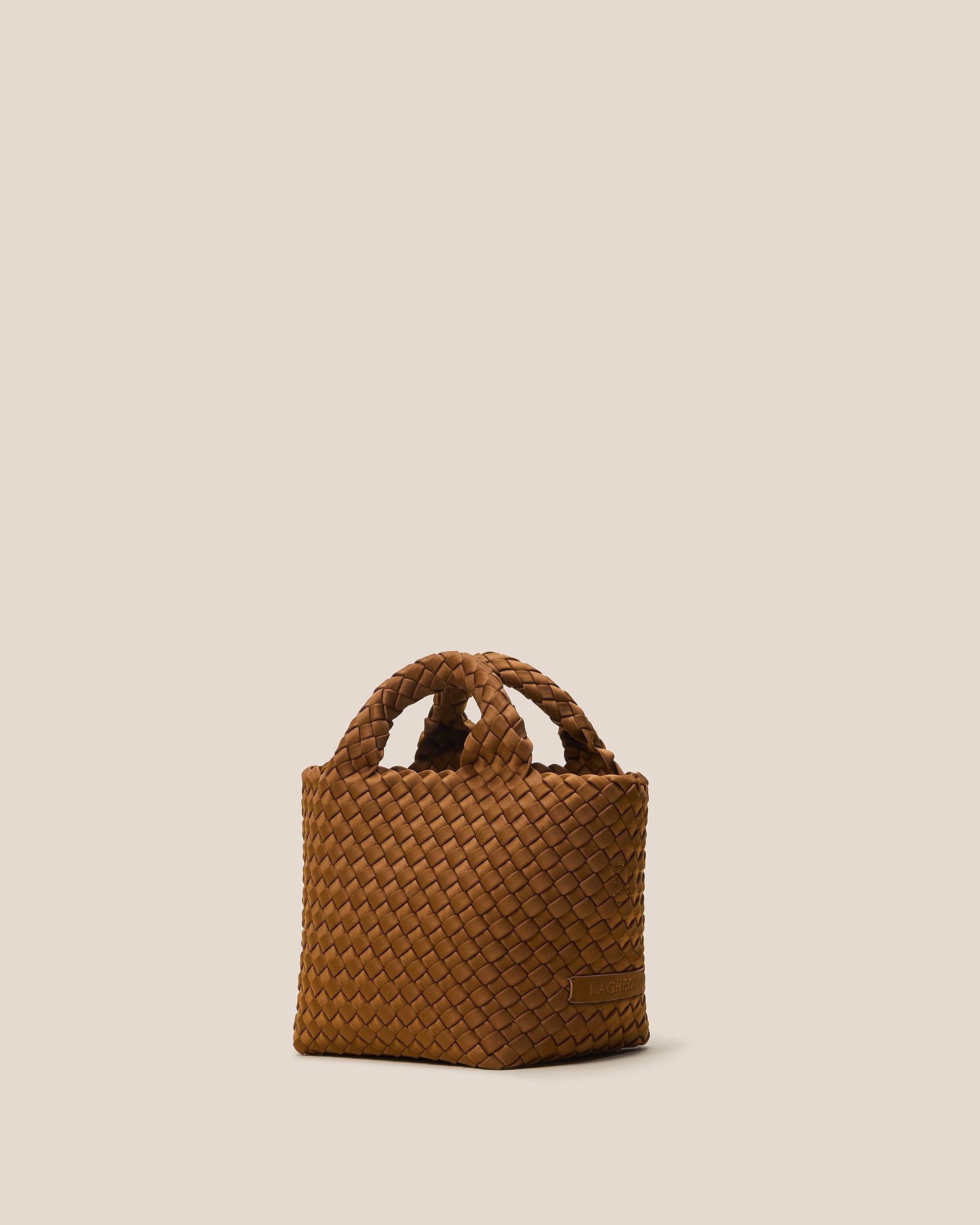 St. Barths Tote in Teak shown from a side angle, highlighting its handwoven neoprene construction and open top.