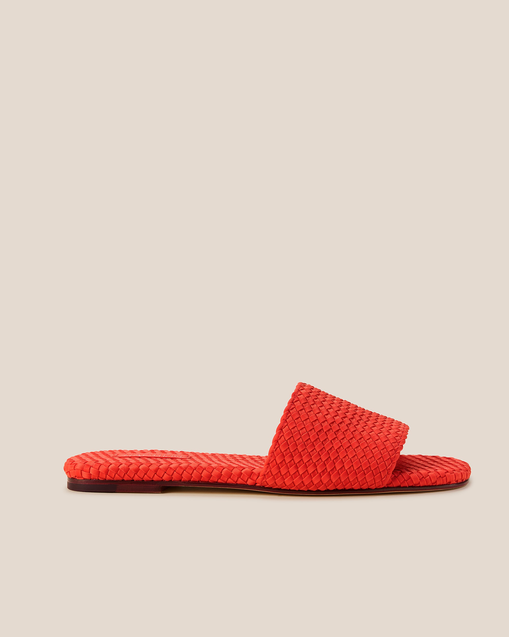 Side view of The St. Barths Slide in Ipanema, a vibrant orange tone, featuring an open toe and square silhouette.