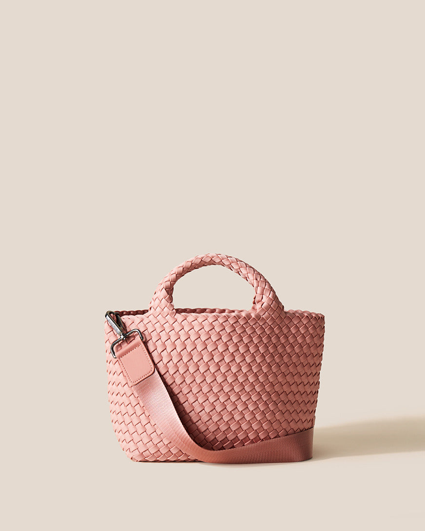 St. Barths Tote in Dusk, a dusty rose pink tone, in handwoven neoprene, featuring an open top, woven top handles, and detachable, adjustable nylon crossbody strap.