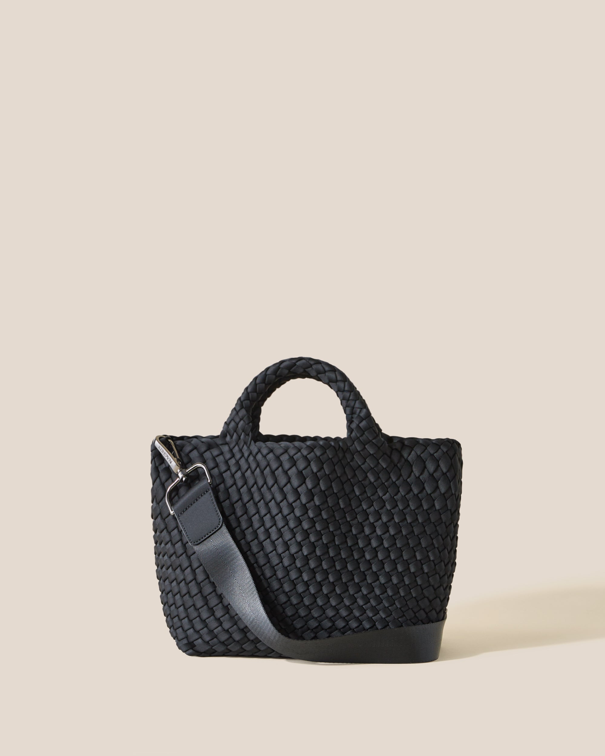 St. Barths Tote in Onyx, a true black tone, in handwoven neoprene, featuring an open top, woven top handles, and detachable, adjustable nylon crossbody strap.