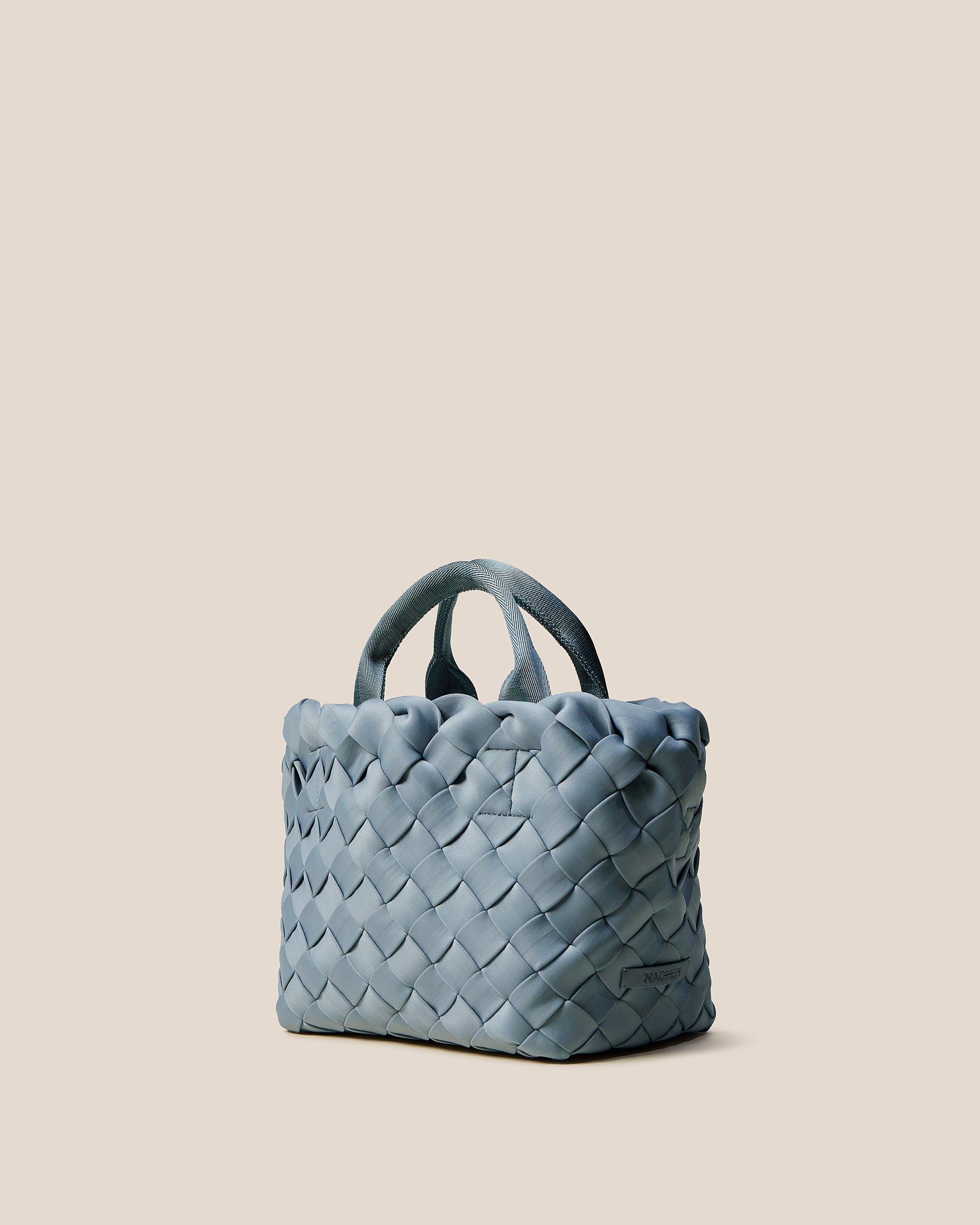 Tangier Tote in Nova shown from a side angle, highlighting its handwoven neoprene construction and open top.