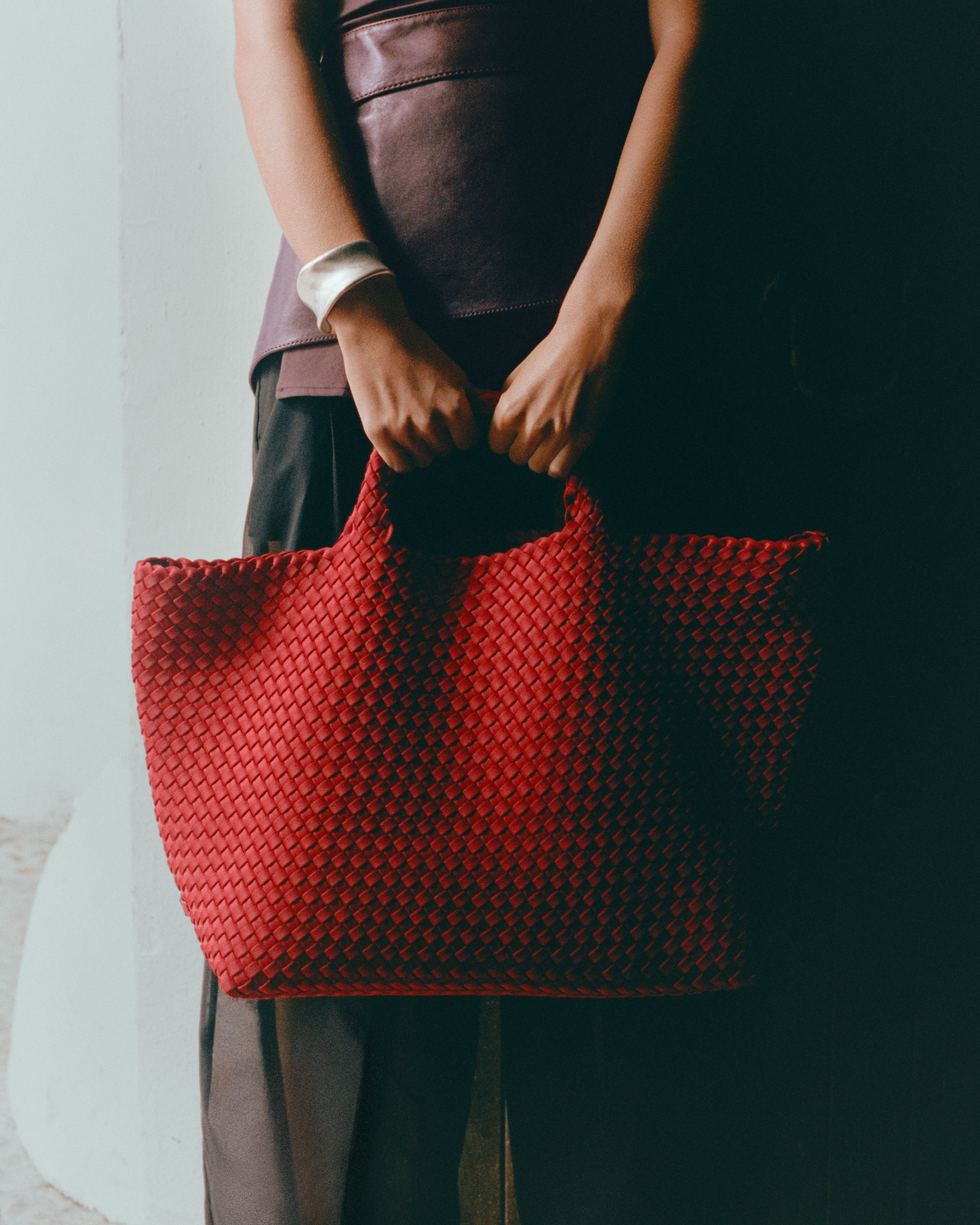 St. Barths Tote in Rosso shown on model to illustrate scale and soft silhouette.