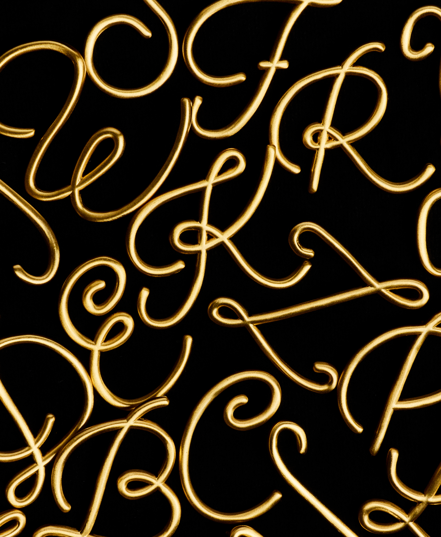 Gold cursive letters on a black background