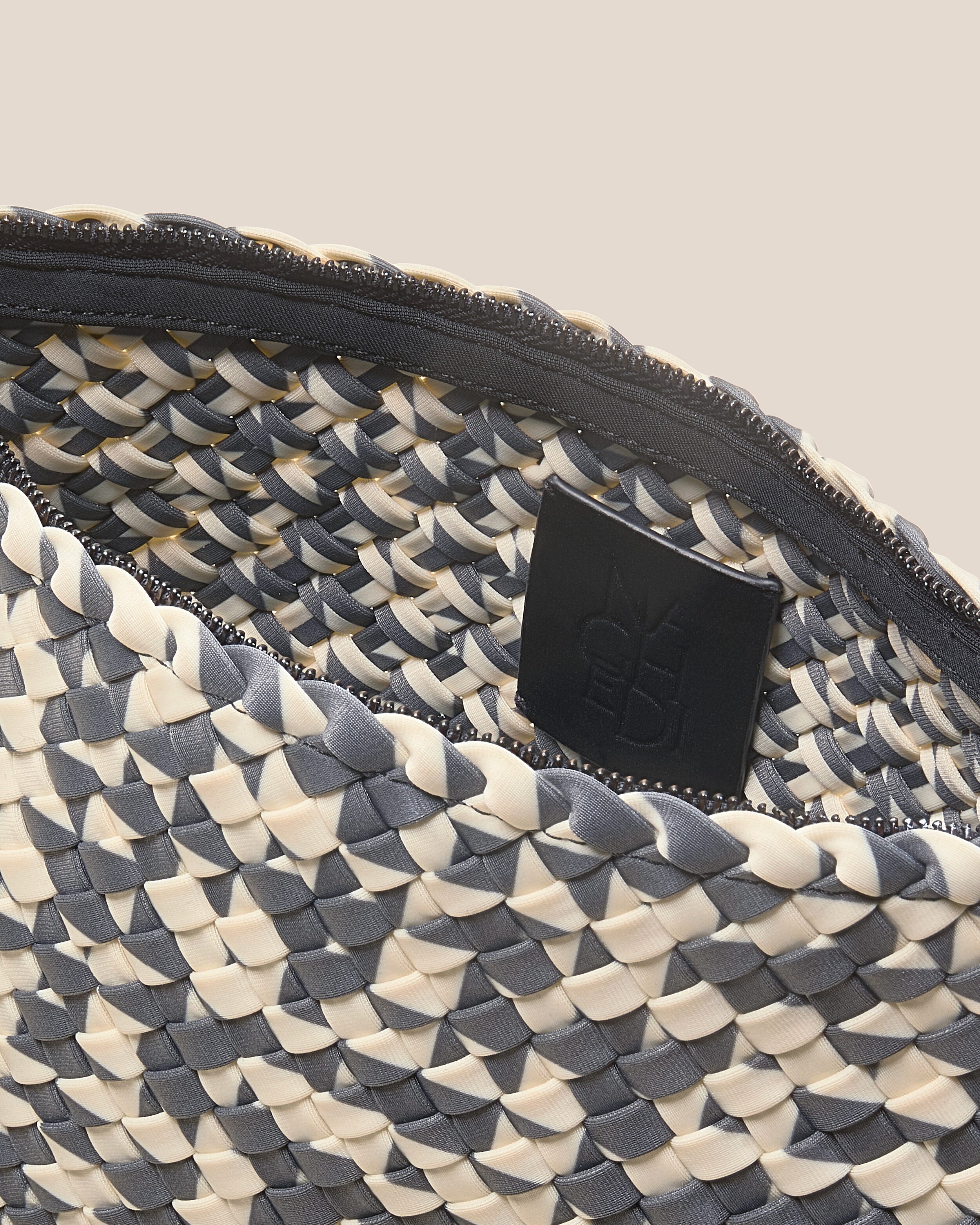 Interior close-up of Antibes Clutch in Abalone showing its zip closure with gunmental hardware, and unlined interior.