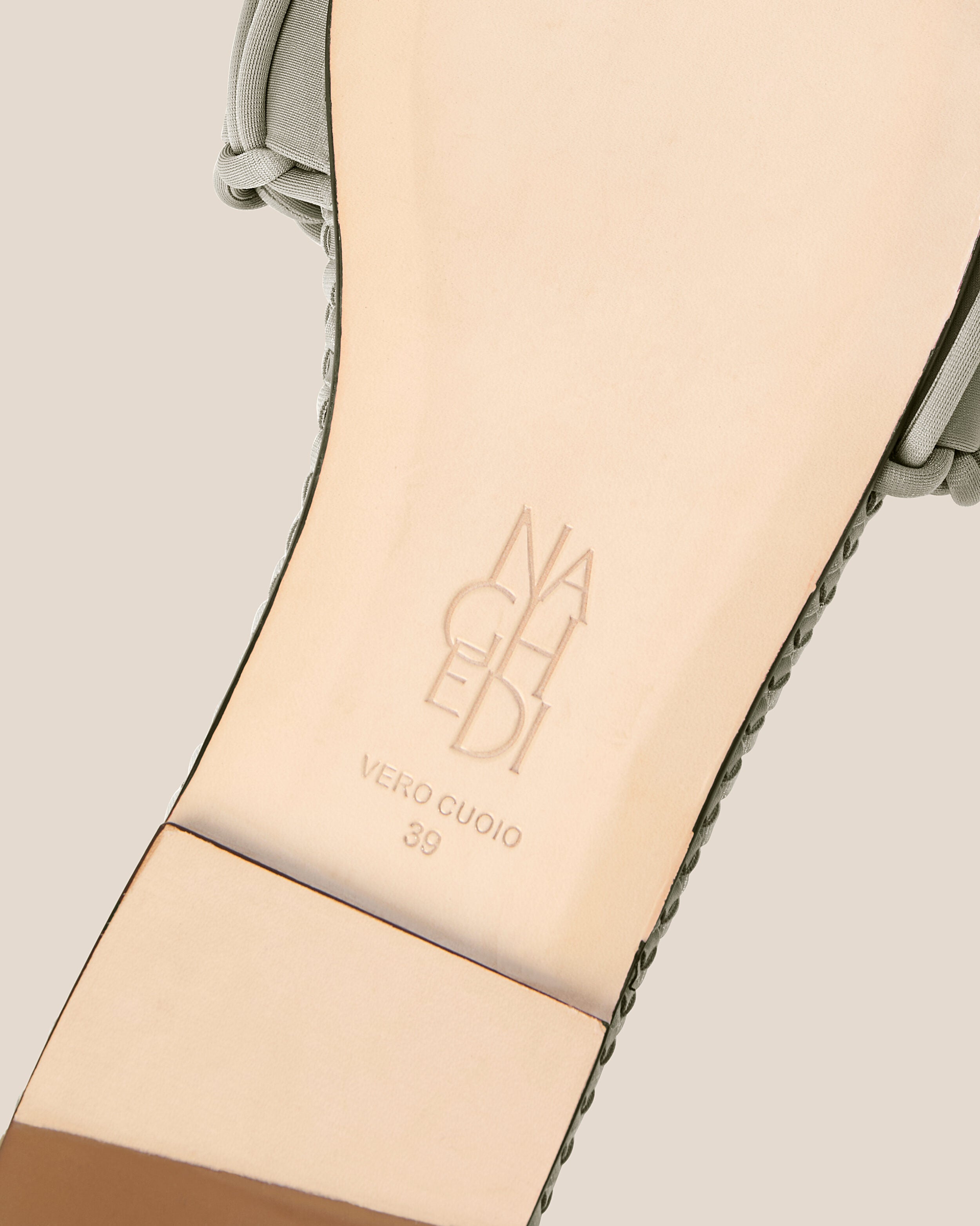 Shoe sole showing natural buffed leather sole, stamped NAGHEDI logo and size detail for The Athens Slide in Celadon.
