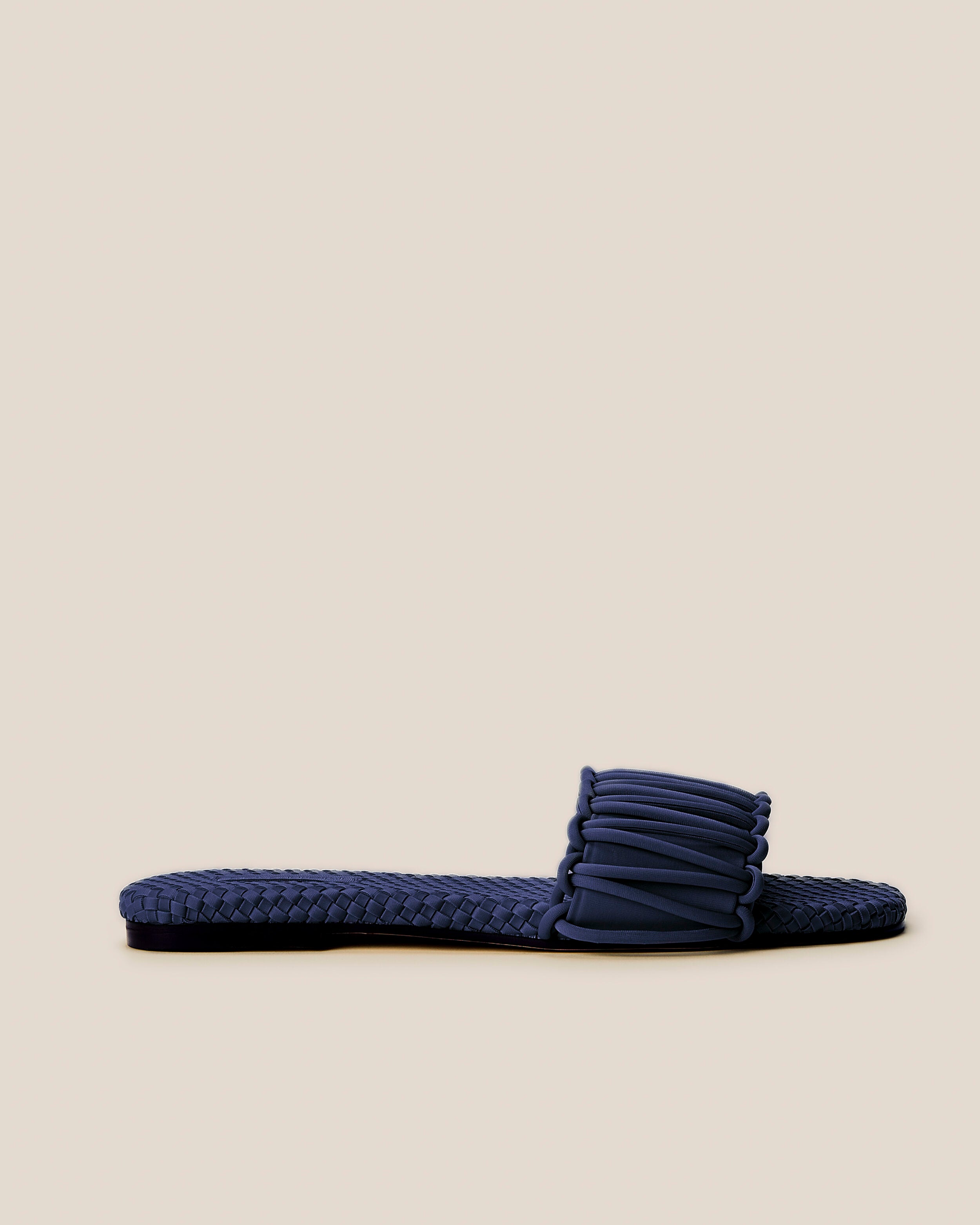 Side view of The Athens Slide in Ink Blue, a navy blue tone, featuring an open toe and square silhouette.