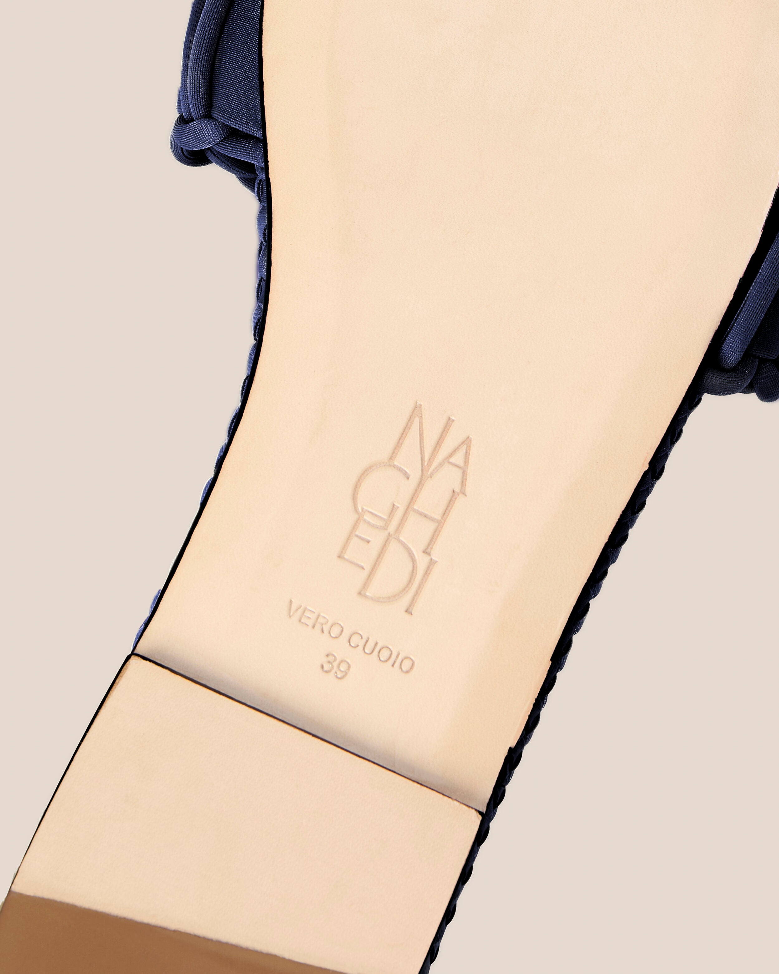 Shoe sole showing natural buffed leather sole, stamped NAGHEDI logo and size detail for The Athens Slide in Ink Blue.