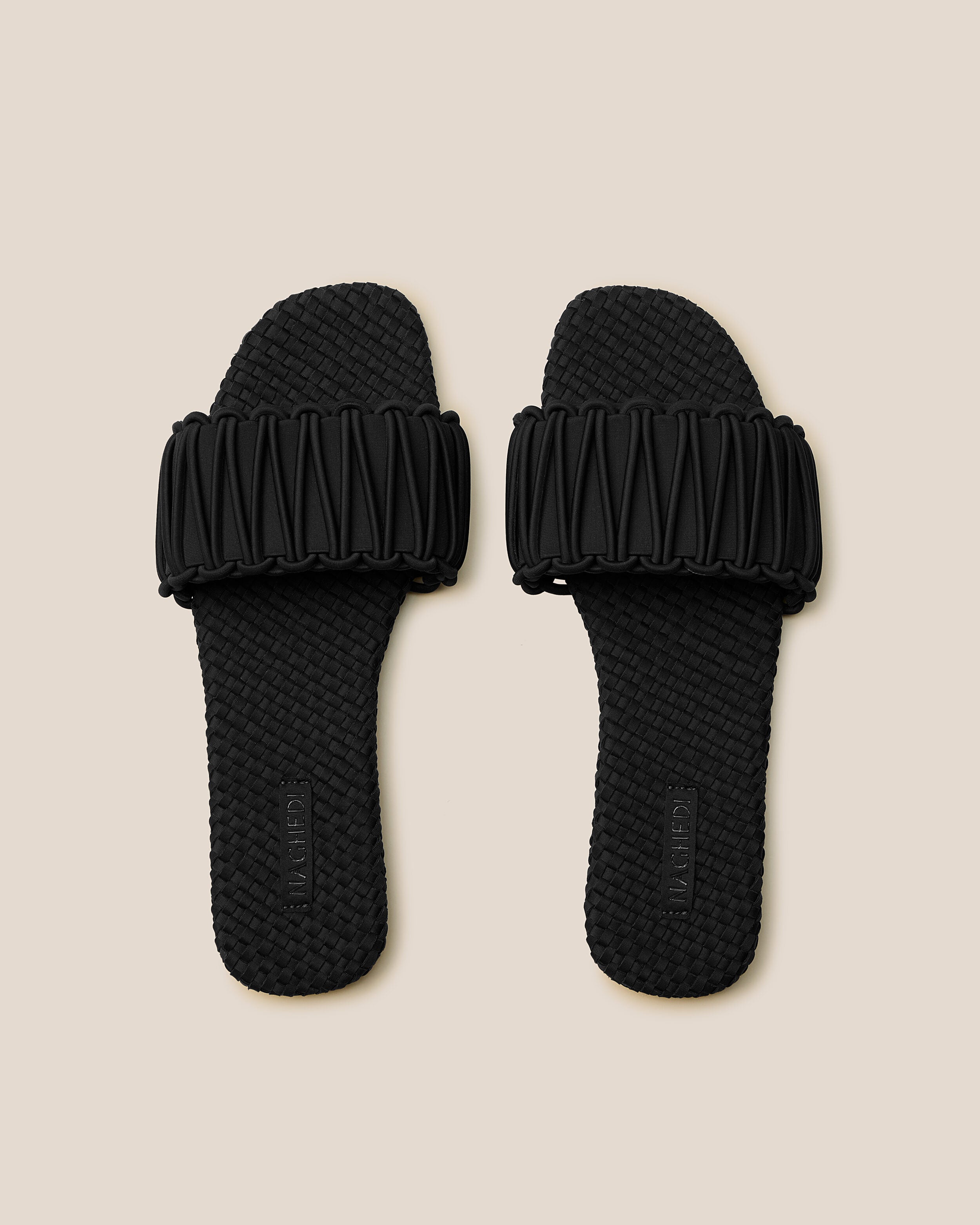 Top view of pair of The Athens Slide in Onyx showing the handwoven neoprene insole.