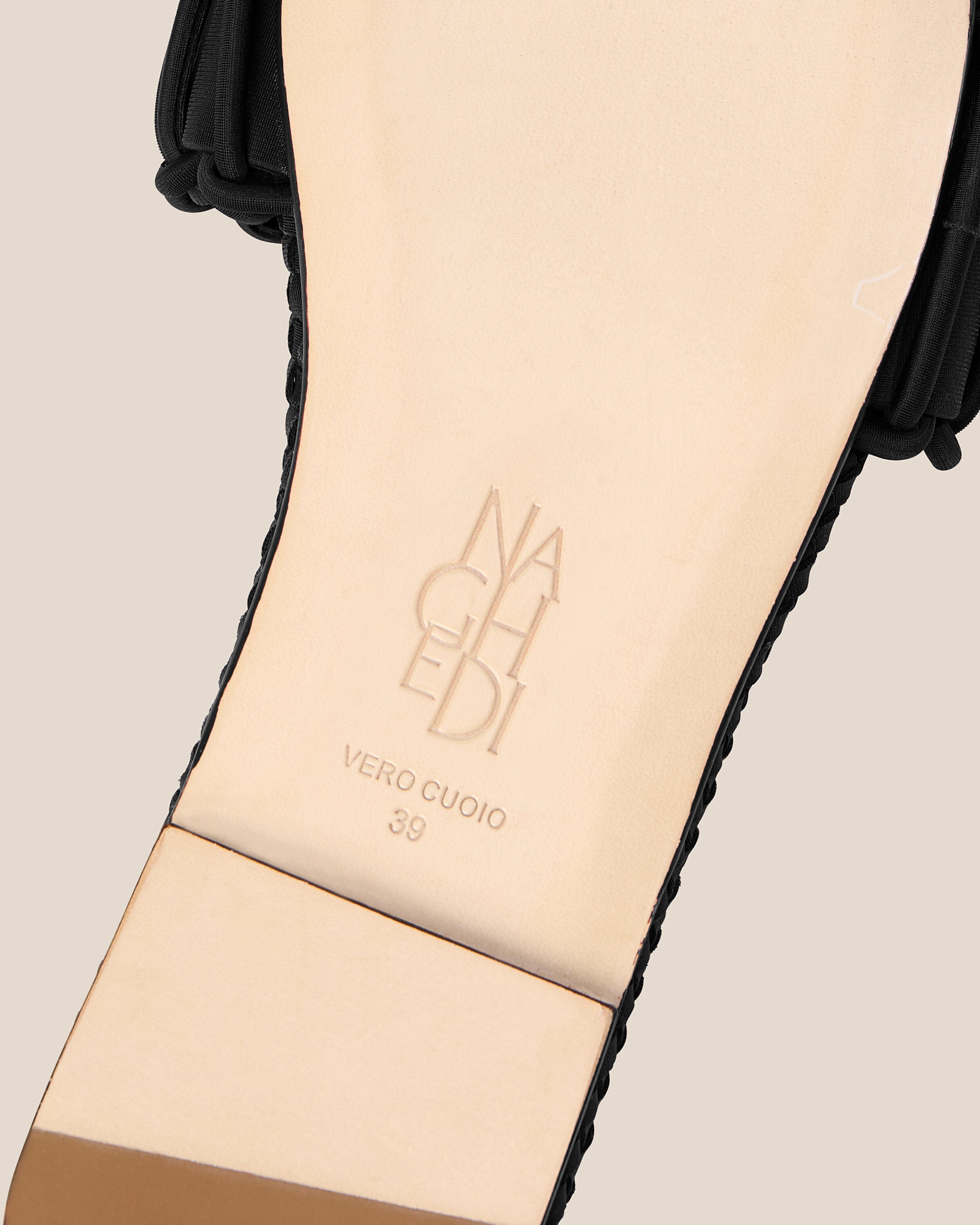 Shoe sole showing natural buffed leather sole, stamped NAGHEDI logo and size detail for The Athens Slide in Onyx.