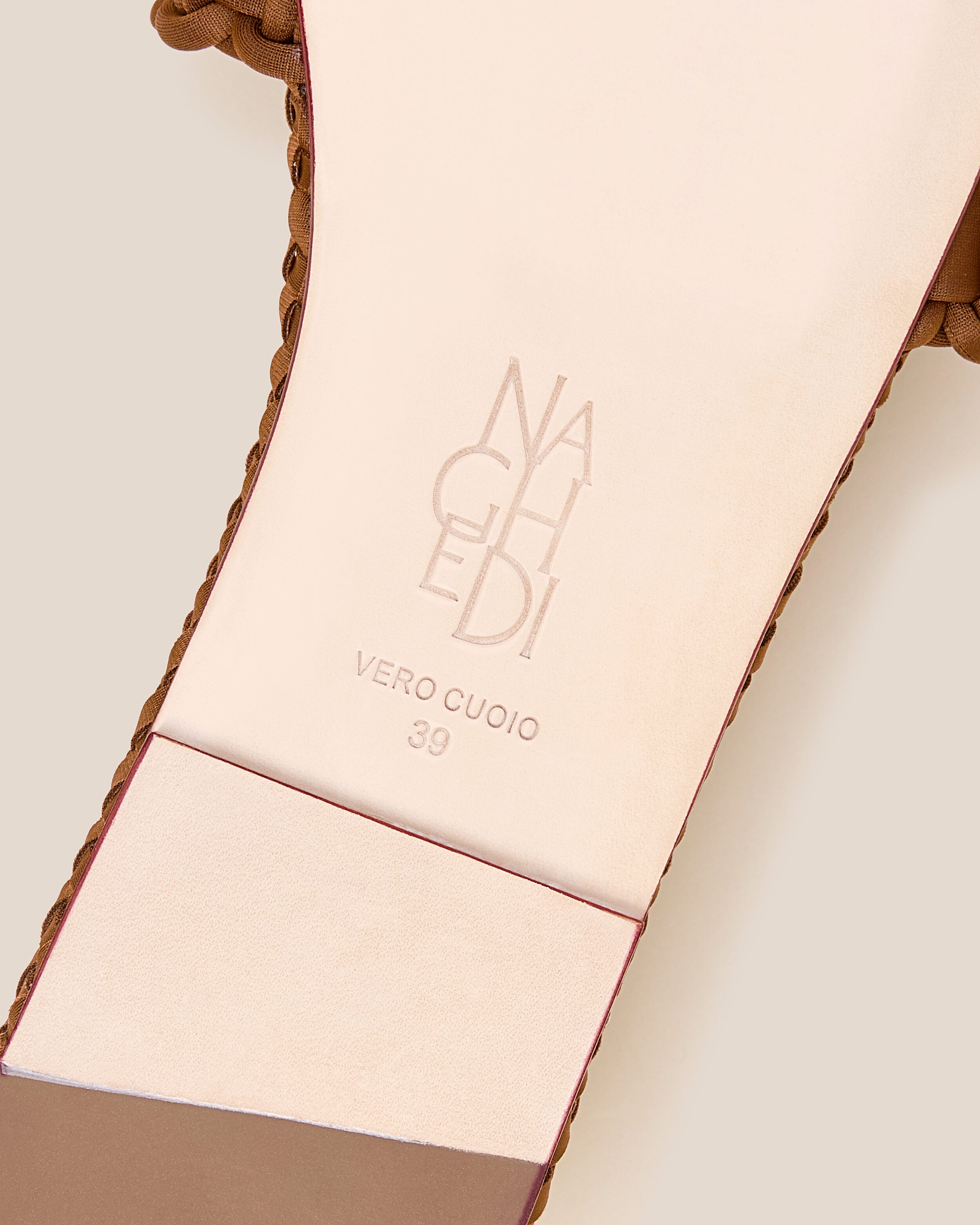 Shoe sole showing natural buffed leather sole, stamped NAGHEDI logo and size detail for The Athens Slide in Teak.