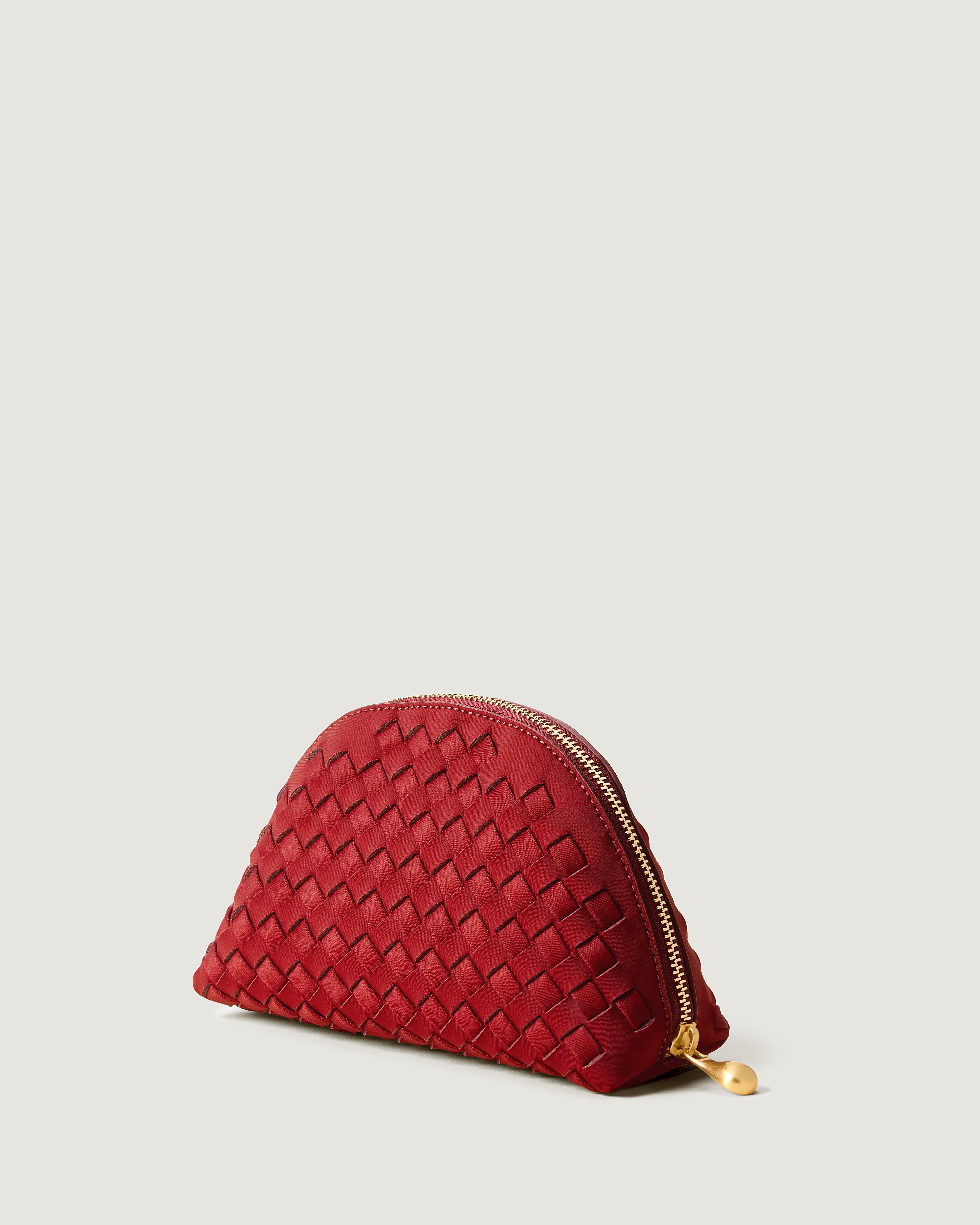 Atlas Cosmetic Case in Rosso shown from a side angle, highlighting its handwoven neoprene construction and wrap-around zip closure.