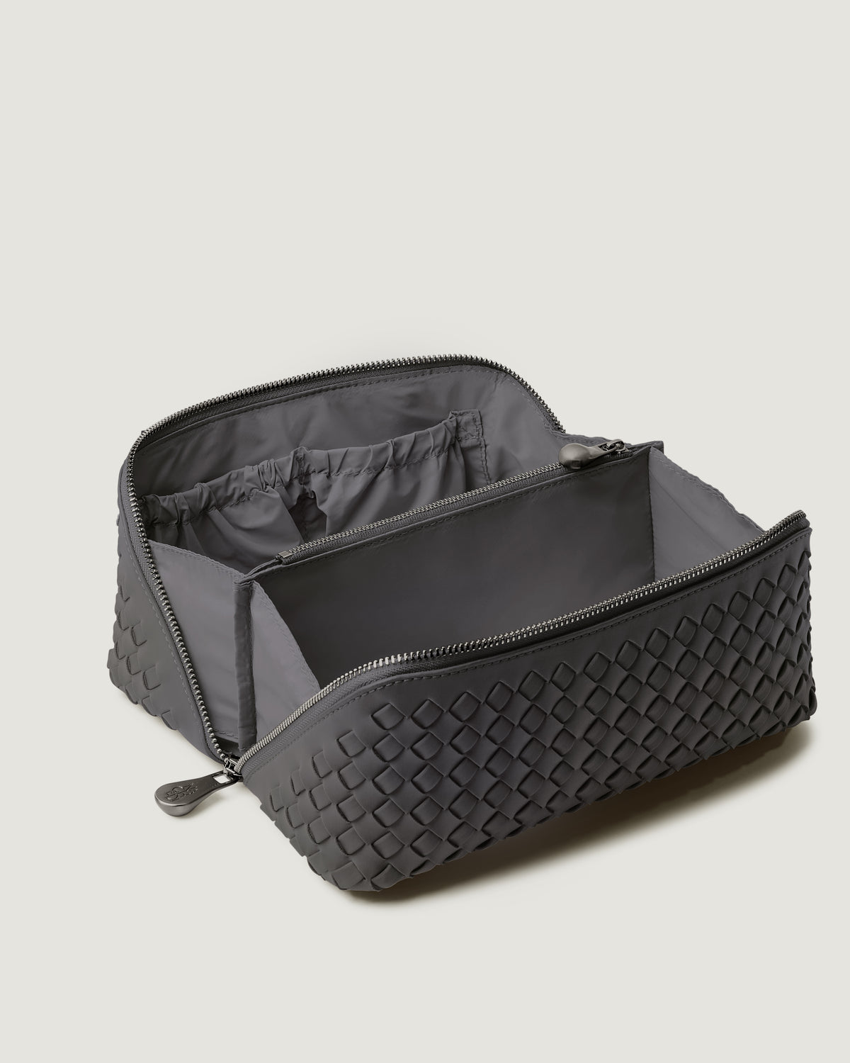 Interior close-up of Caravan Cosmetic Case in Ash showing its wrap-around zip closure, and wipe-clean nylon interior.