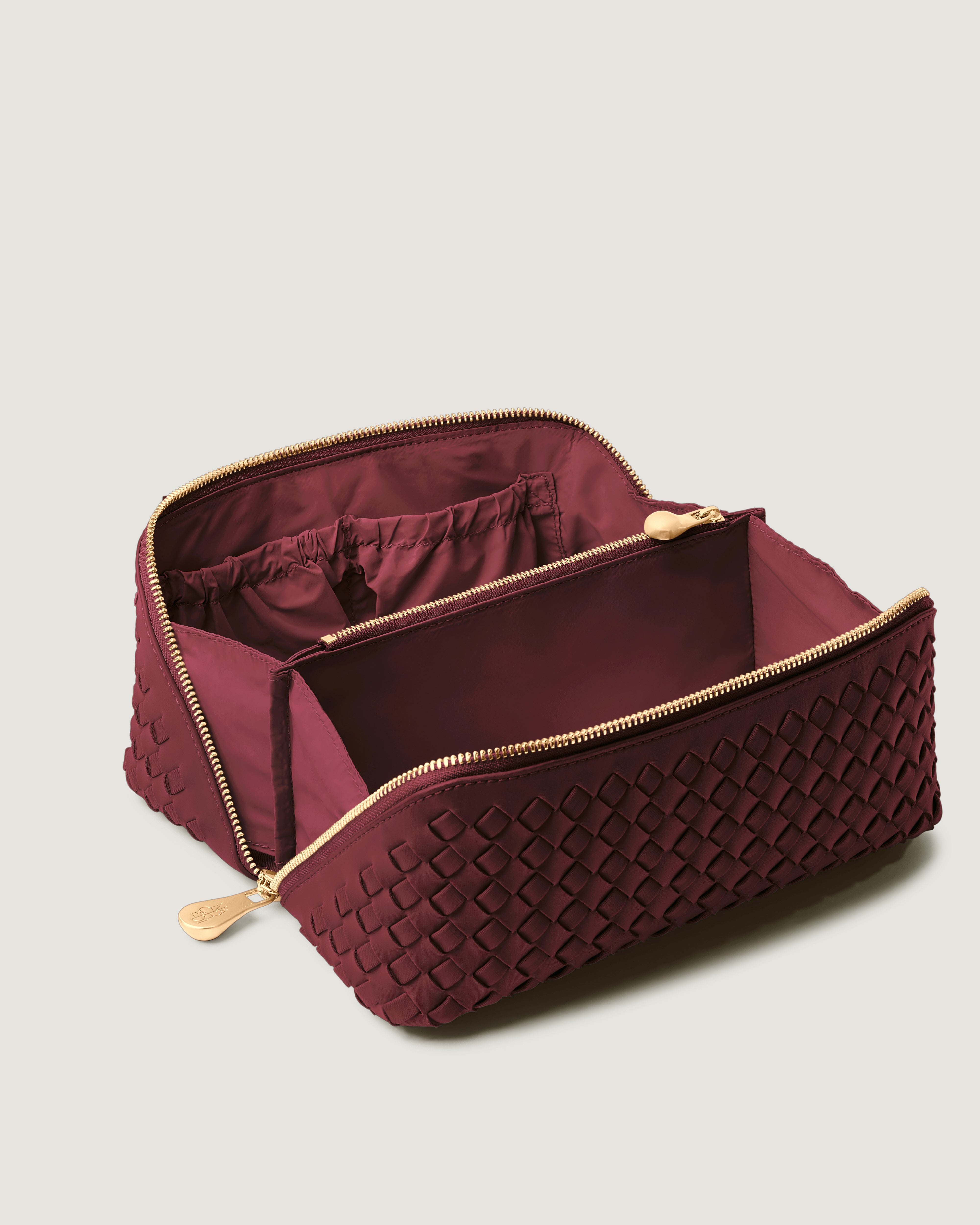 Interior close-up of Caravan Cosmetic Case in Bordeaux showing its wrap-around zip closure, and wipe-clean nylon interior.