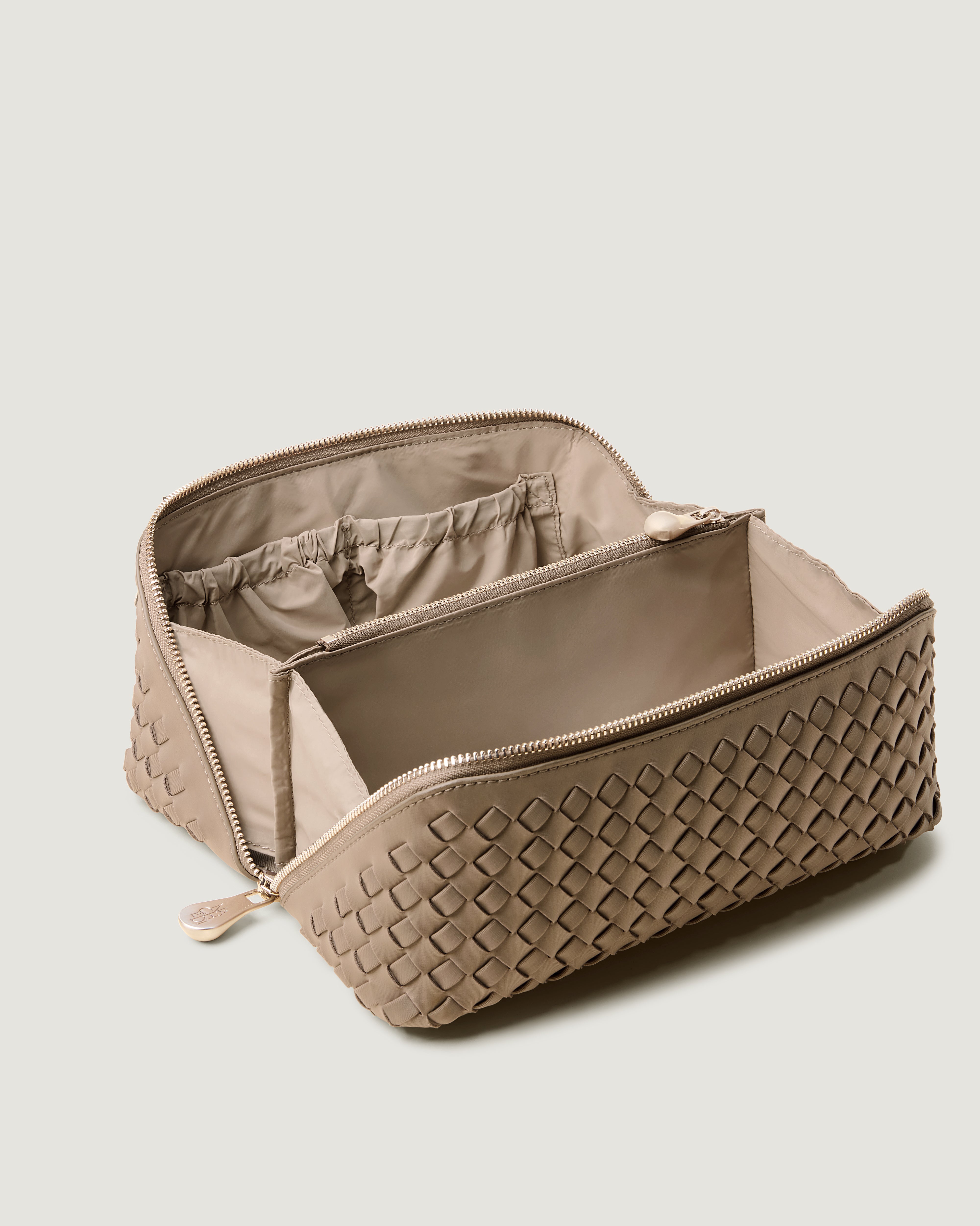 Interior close-up of Caravan Cosmetic Case in Cashmere showing its wrap-around zip closure, and wipe-clean nylon interior.