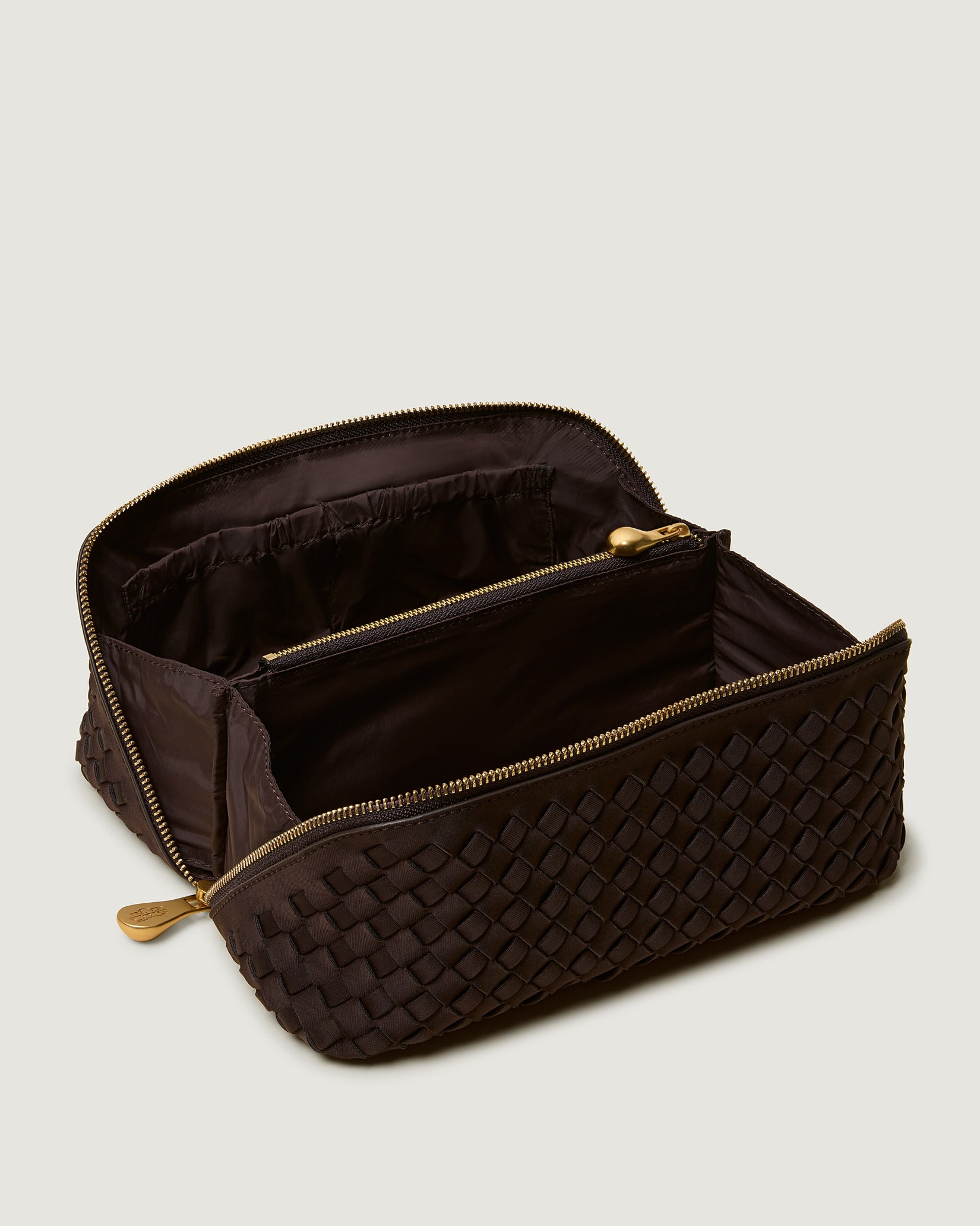 Interior close-up of Caravan Medium Cosmetic Case in Chocolate showing its wrap-around zip closure, and wipe-clean nylon interior.
