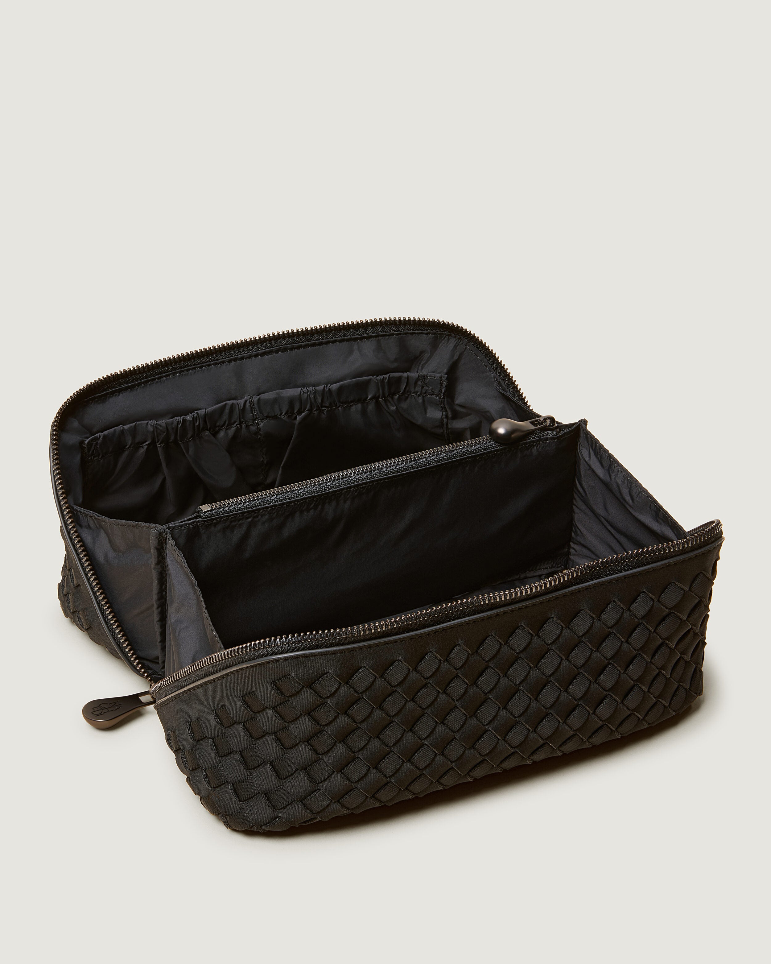 Interior close-up of Caravan Cosmetic Case in Onyx showing its wrap-around zip closure, and wipe-clean nylon interior.