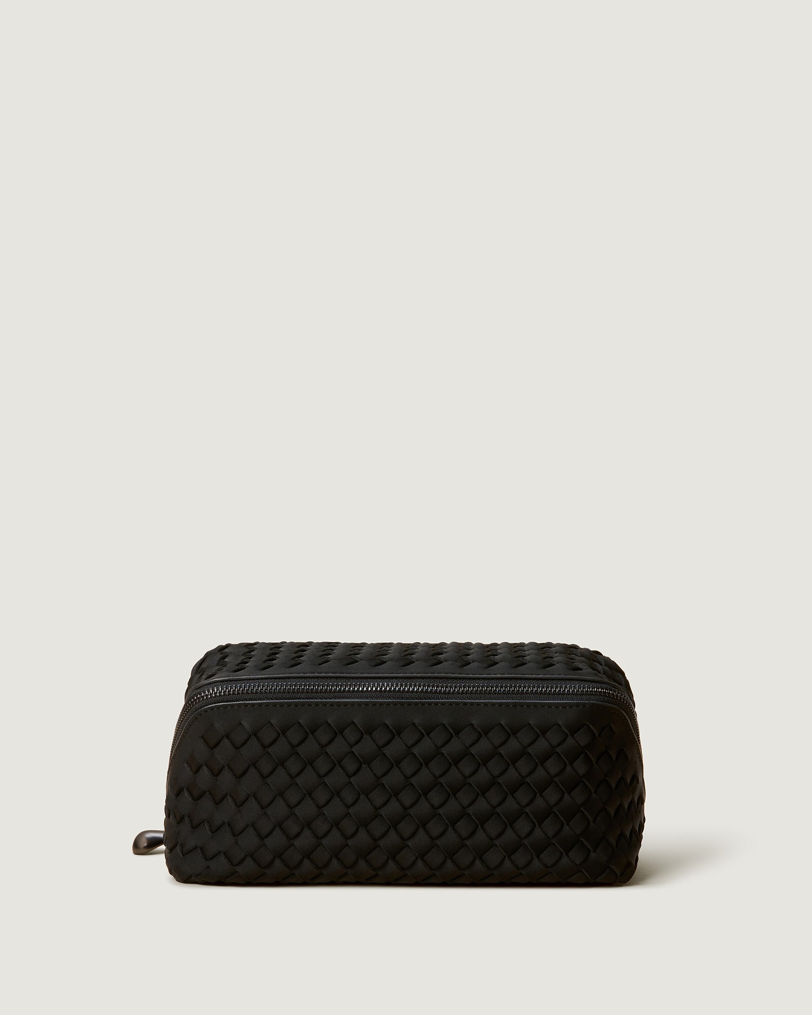 Caravan Medium Cosmetic Case in Onyx, a true black tone, in handwoven neoprene featuring a wrap-around zip closure.