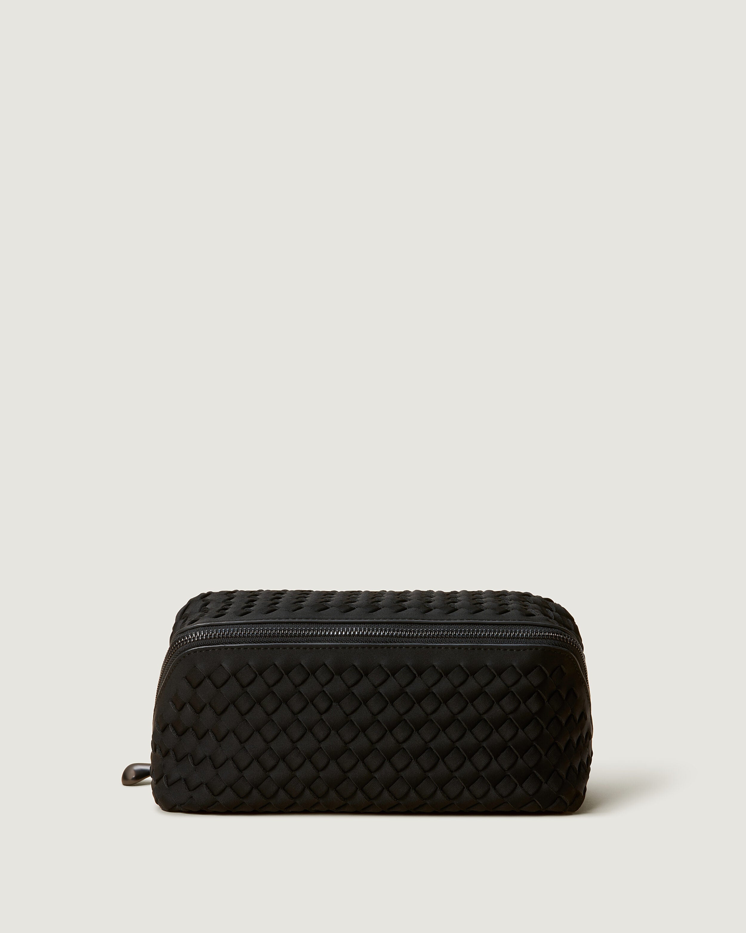 Caravan Cosmetic Case in Onyx, a true black tone, in handwoven neoprene, featuring a wrap-around zip closure.