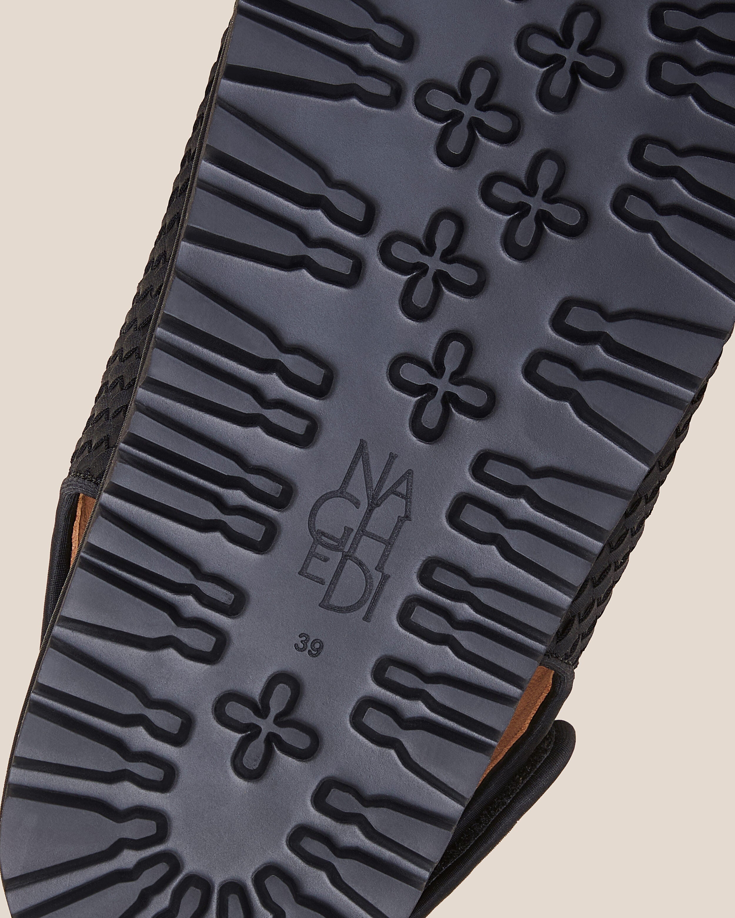 Shoe sole showing extra lightweight eva sole, stamped NAGHEDI logo and size detail for The Catalina Sandal in Onyx.