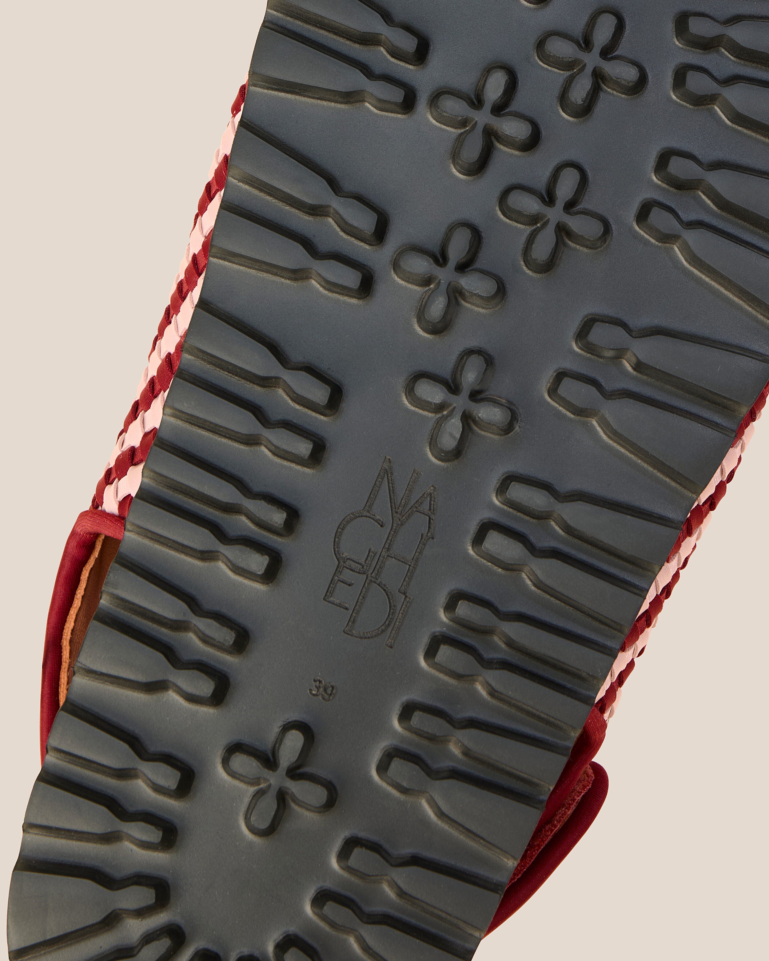 Shoe sole showing extra lightweight eva sole, stamped NAGHEDI logo and size detail for The Catalina Sandal in Lychee.
