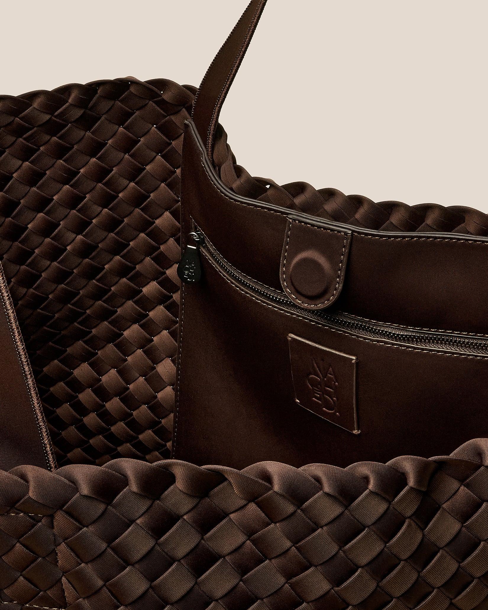 Interior close-up of Como Tote in Chocolate showing its open top with magnetic snap closure, interior zip pocket, and unlined interior.