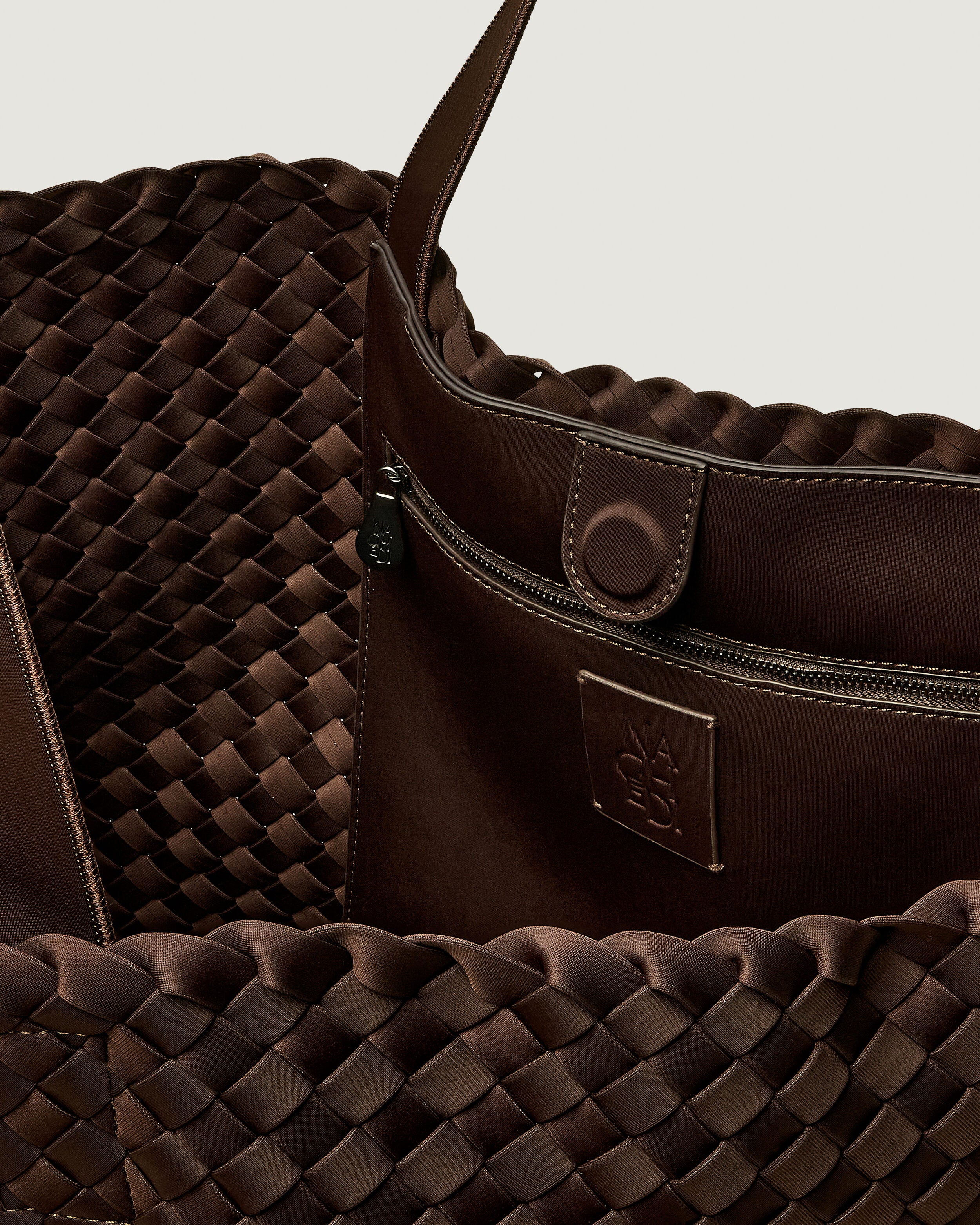 Interior close-up of Como Tote in Chocolate showing its open top with magnetic snap closure, interior zip pocket, and unlined interior.