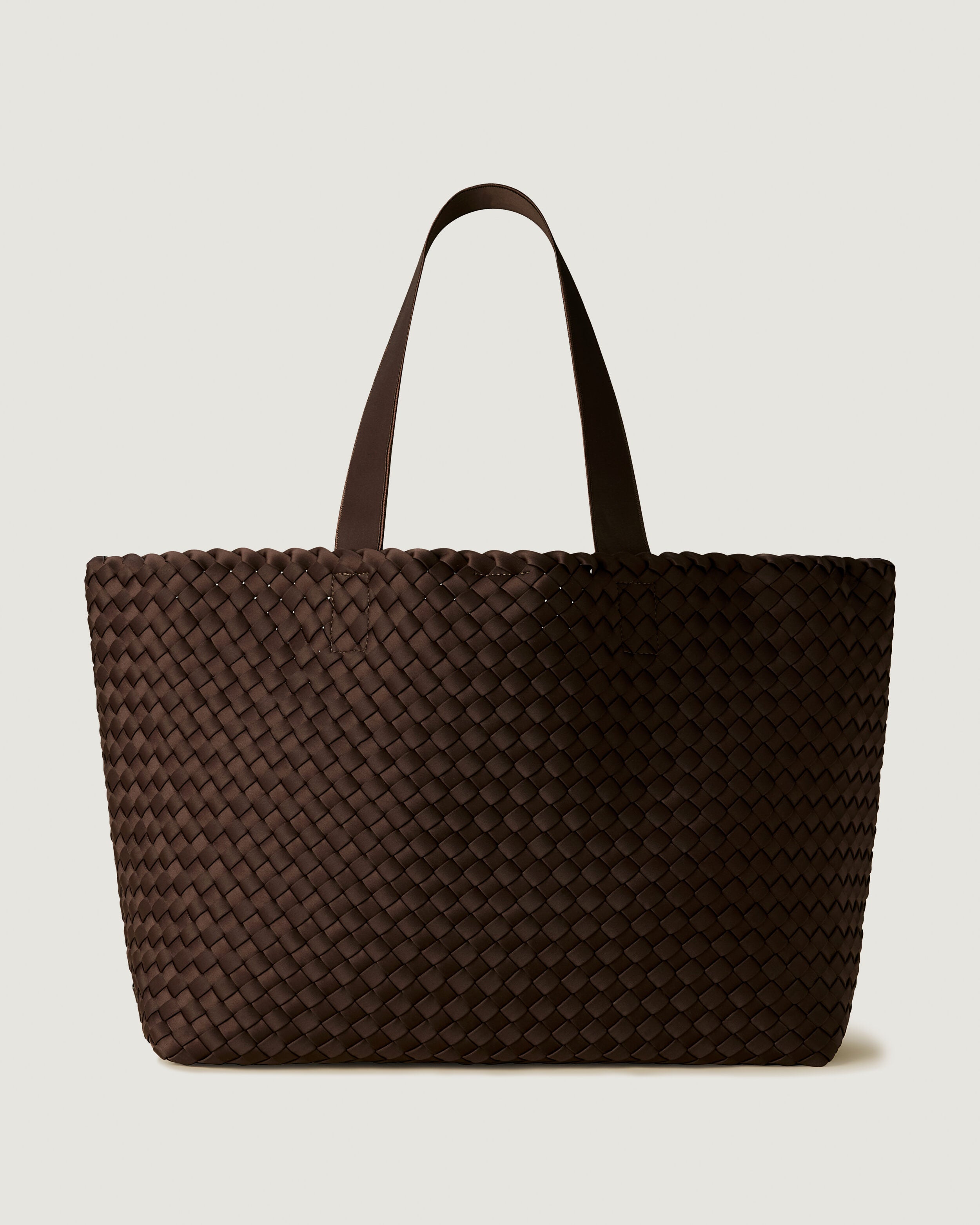 Como Tote in Chocolate, a dark chocolate brown tone, in handwoven neoprene, featuring an open top with magnetic snap closure, and neoprene shoulder straps.