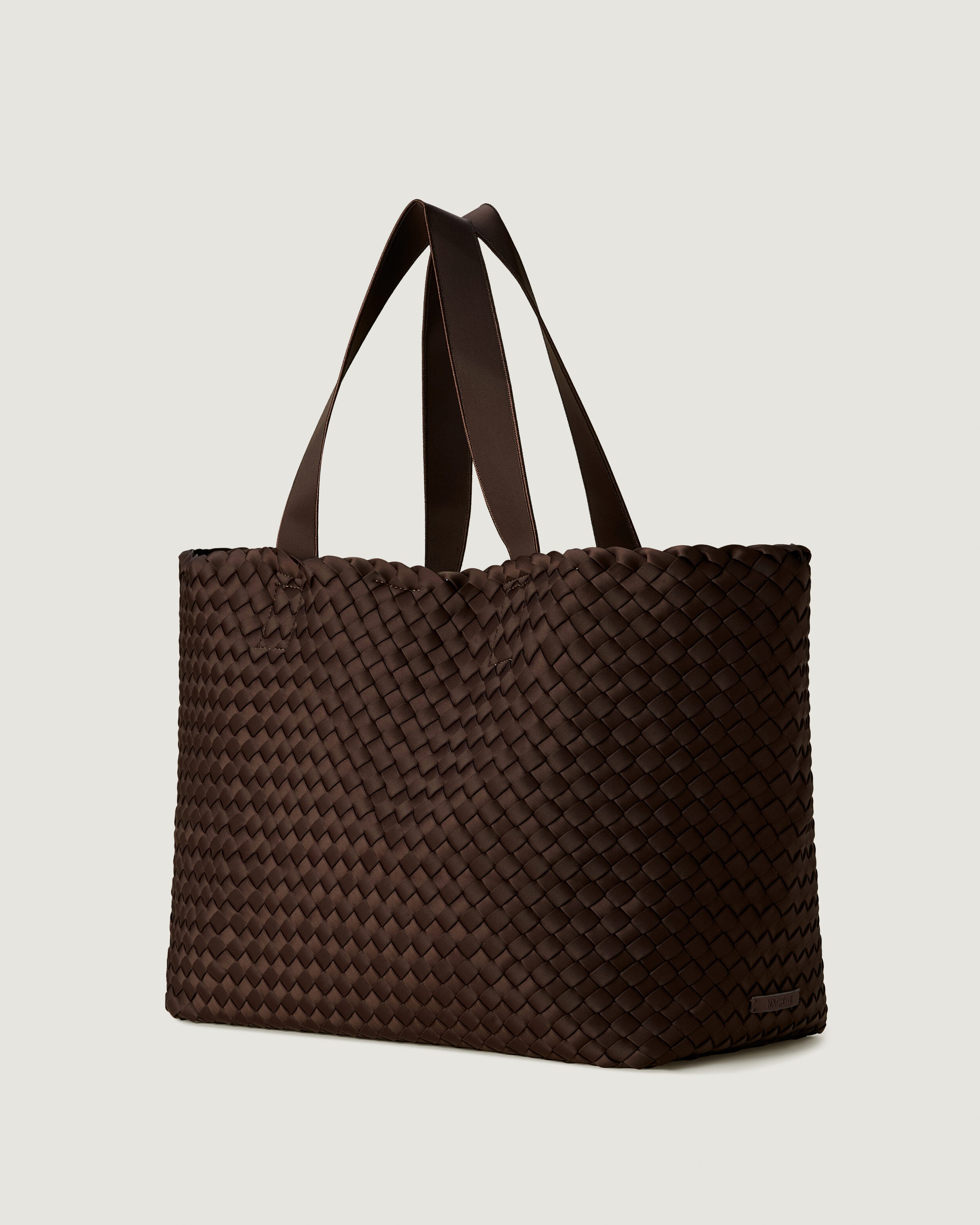 Como Tote in Chocolate shown from a side angle, highlighting its handwoven neoprene construction and open top with magnetic snap closure.
