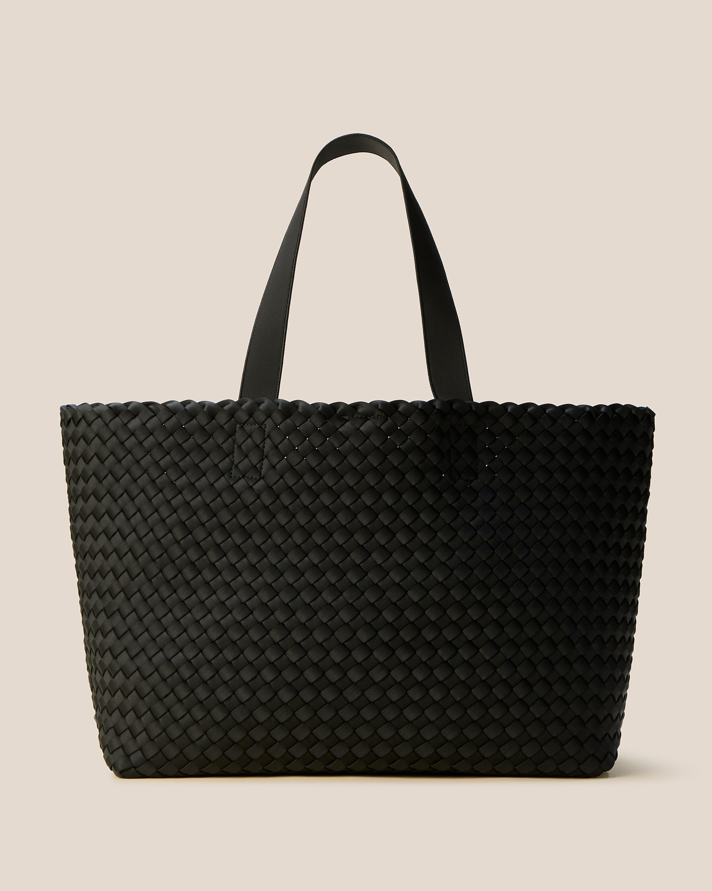 Como Tote in Onyx, a true black tone, in handwoven neoprene, featuring an open top with magnetic snap closure, and neoprene shoulder straps.